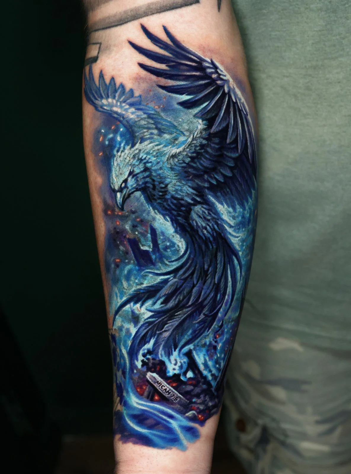 Cover-up after - Javi Antunez reworked the same forearm into a full-color blue phoenix rising from flame.