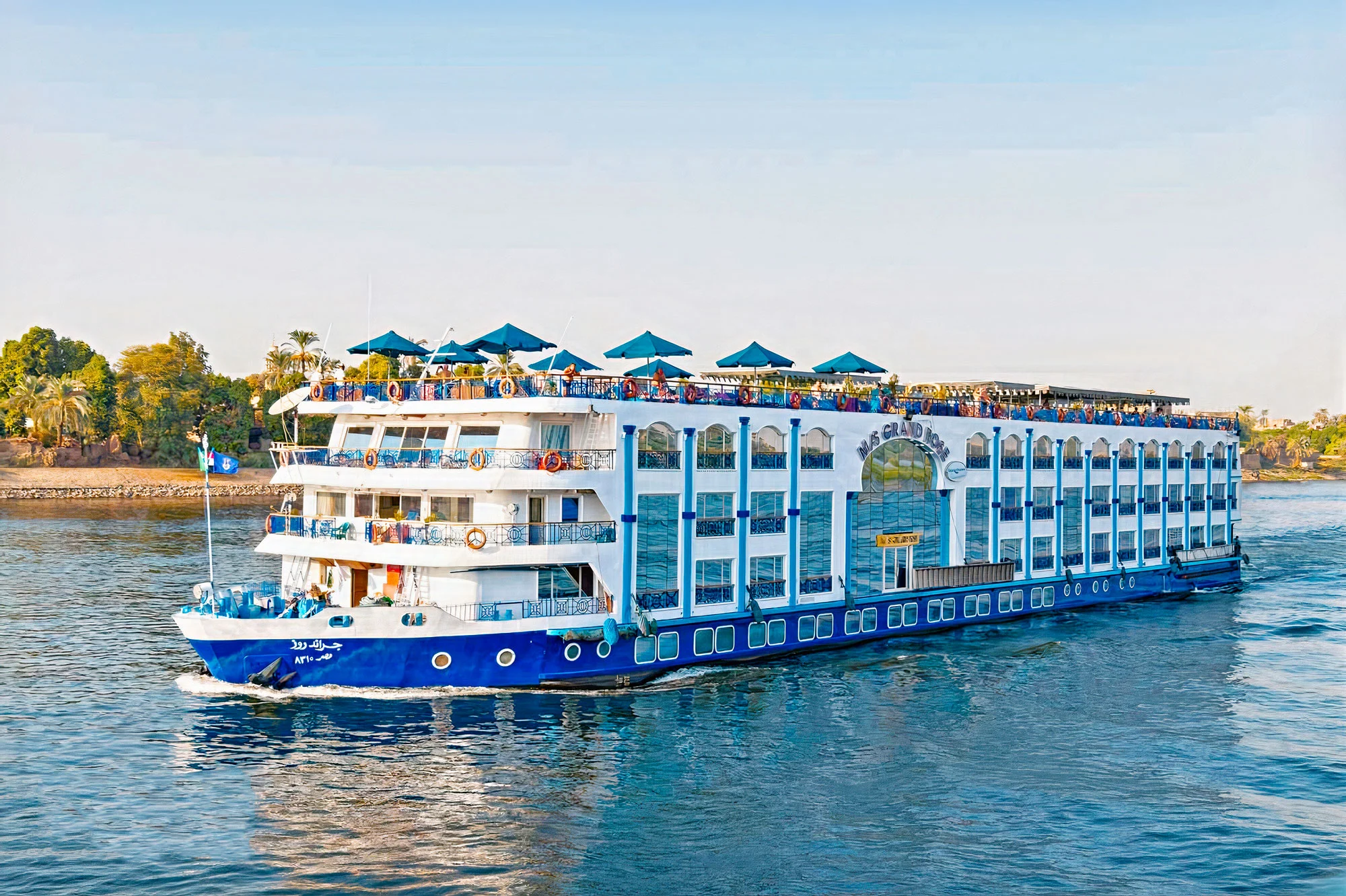 A white-and-blue Nile cruise ship sailing on the river