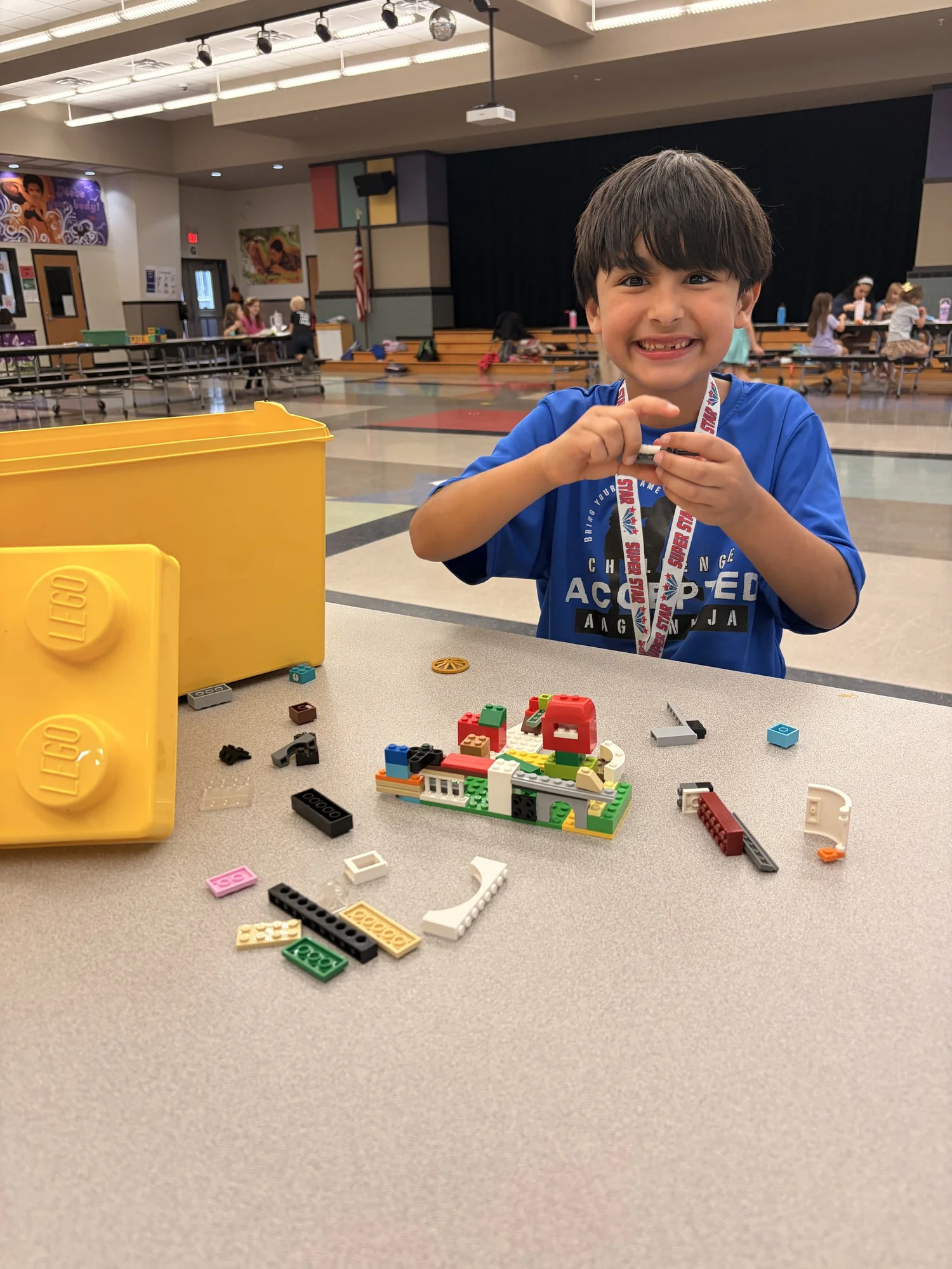 A smiling Texas SuperStars participant building with LEGO bricks
