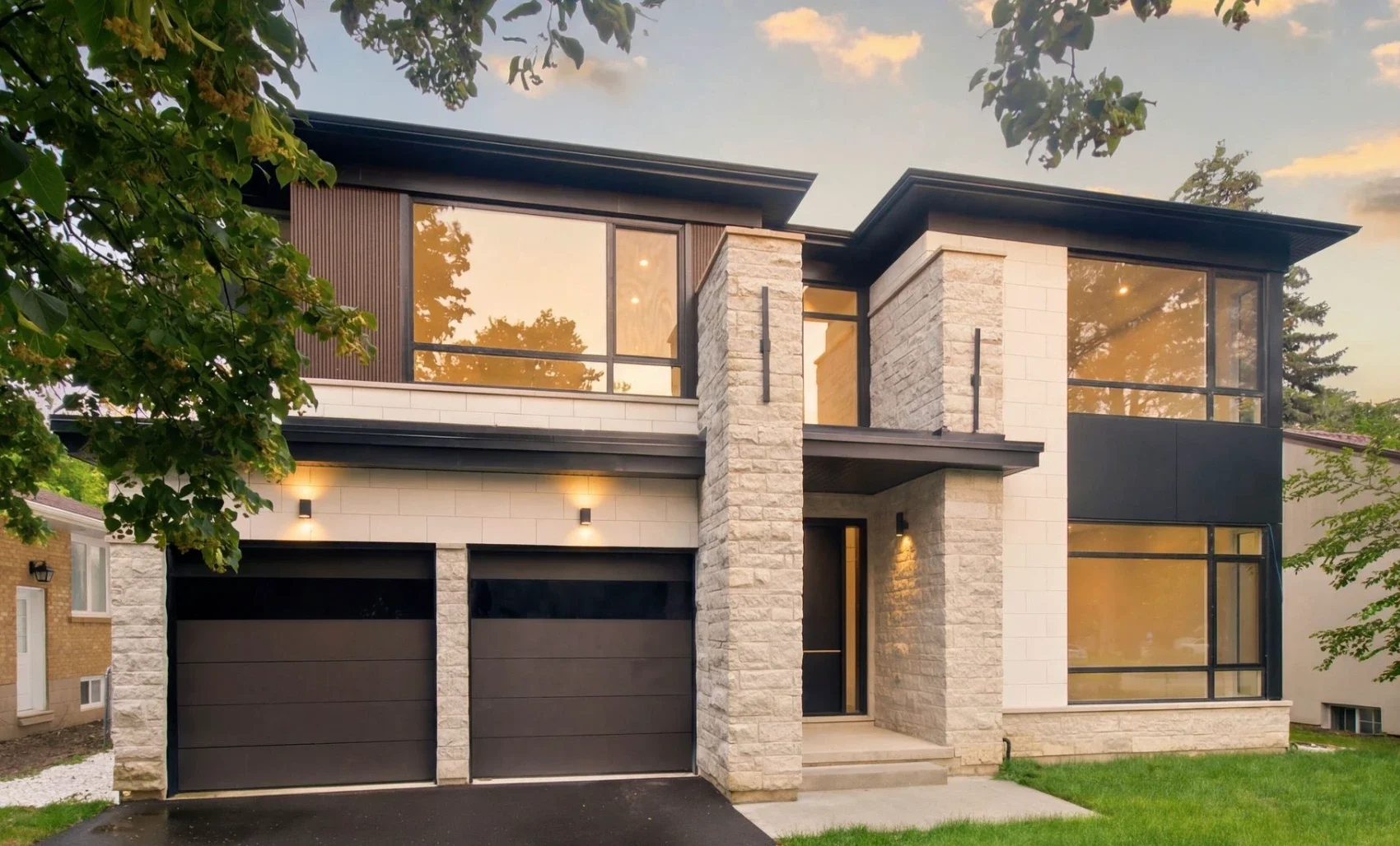 Contemporary two-storey house with large windows, a recessed front entrance and two garage doors