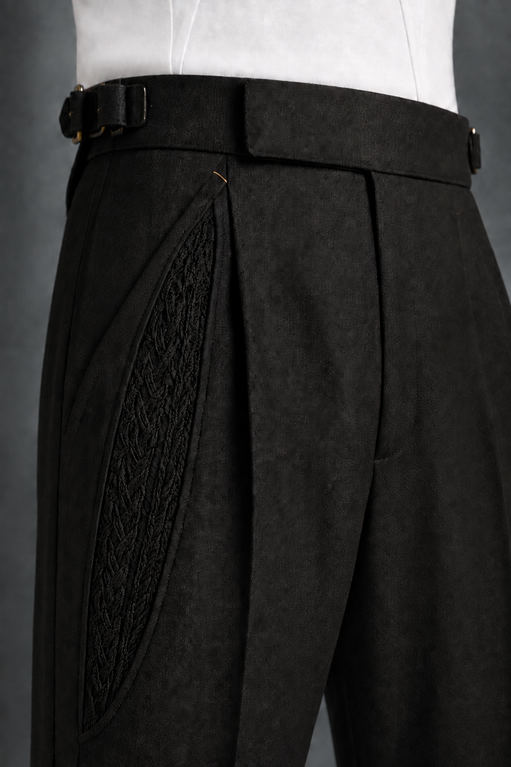 Design study of black trousers with a curved openwork inset and textured fabric