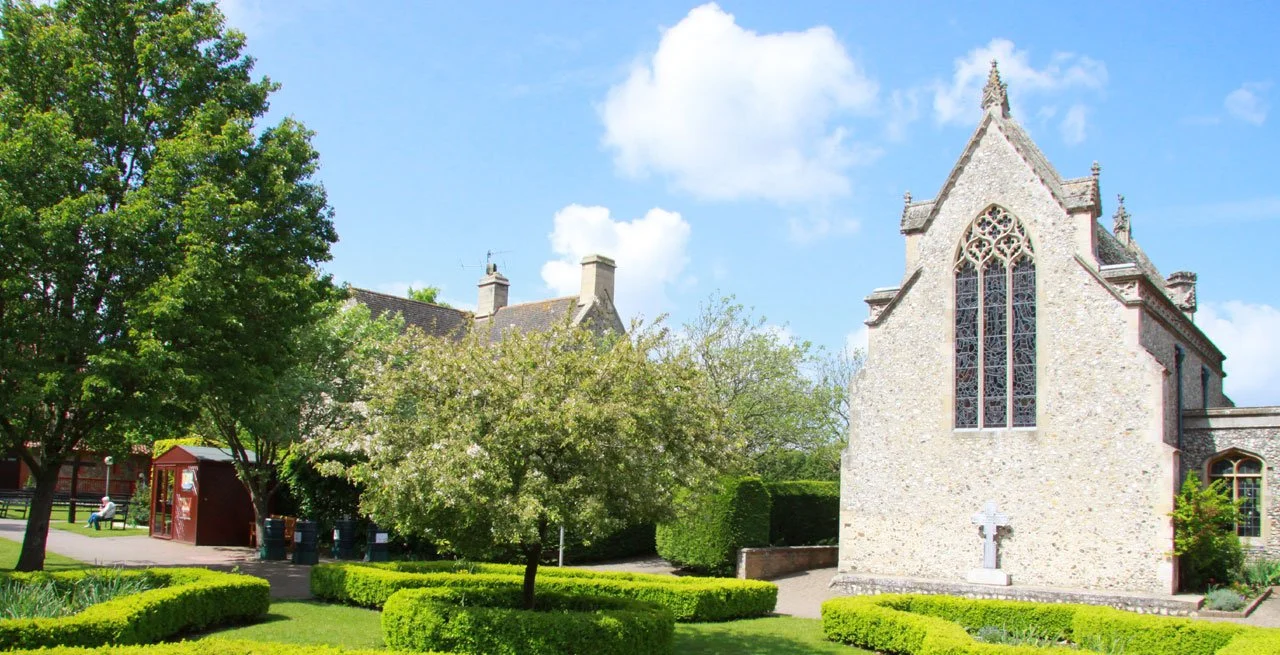 The flint exterior of the Slipper Chapel beside the gardens of Walsingham's Catholic shrine.