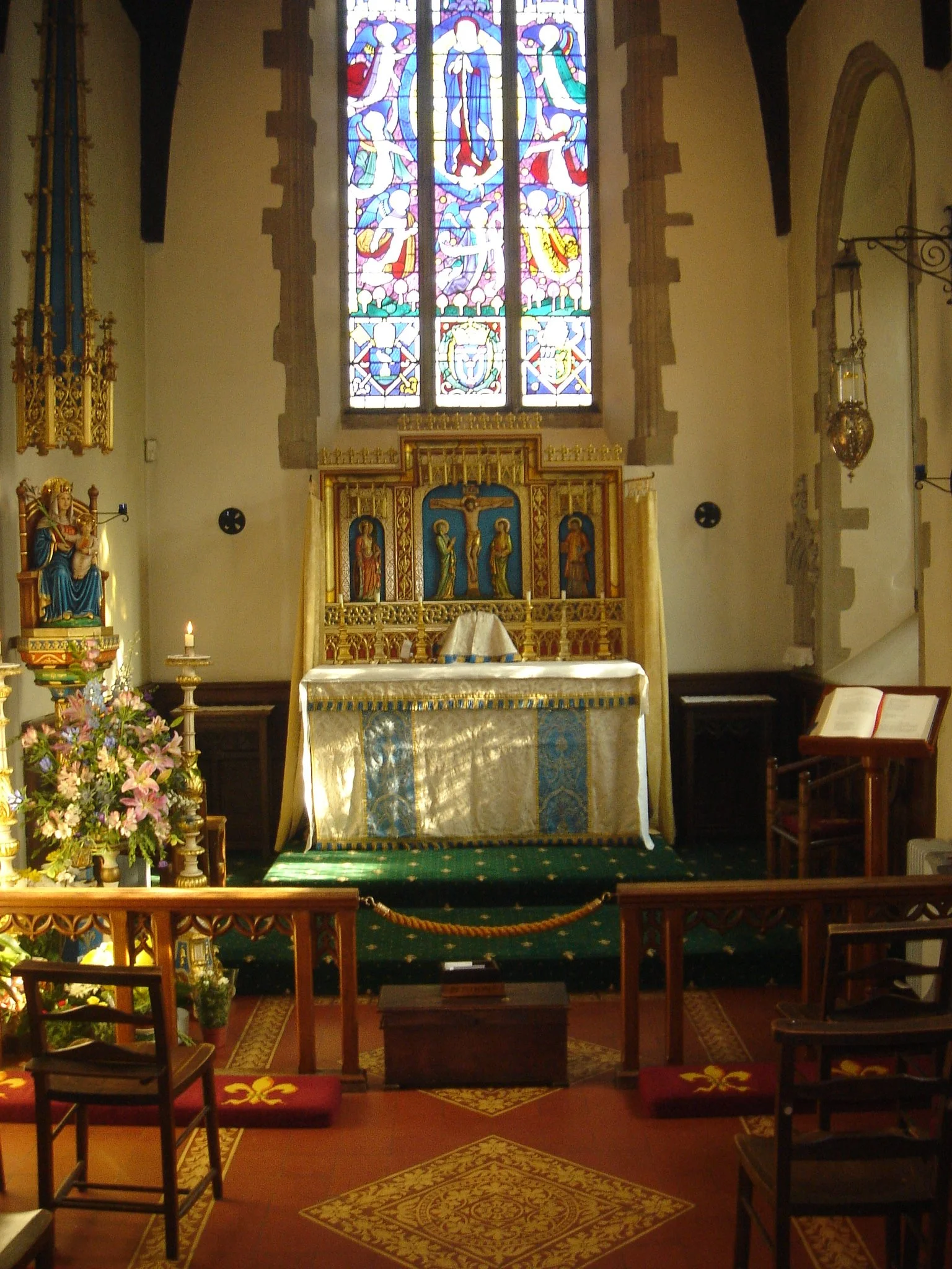 The altar, stained-glass window and statue inside Walsingham's Slipper Chapel.