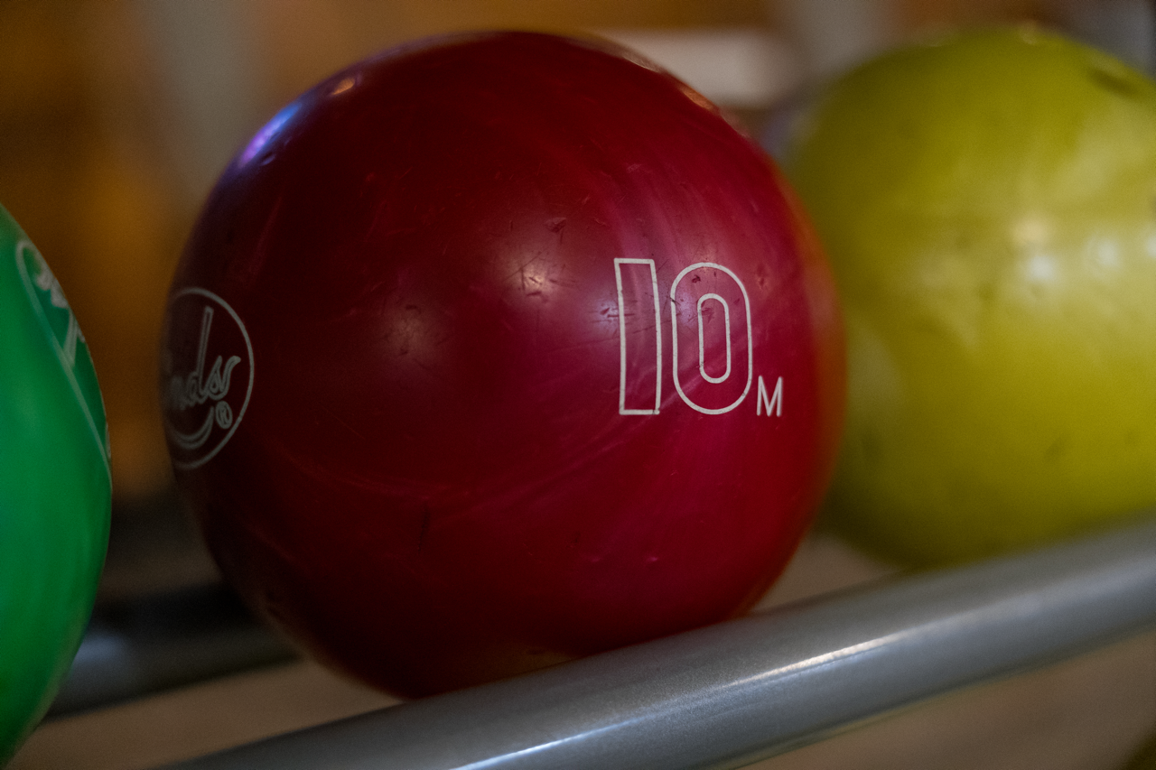A red number 10 house ball waiting on the ball return.