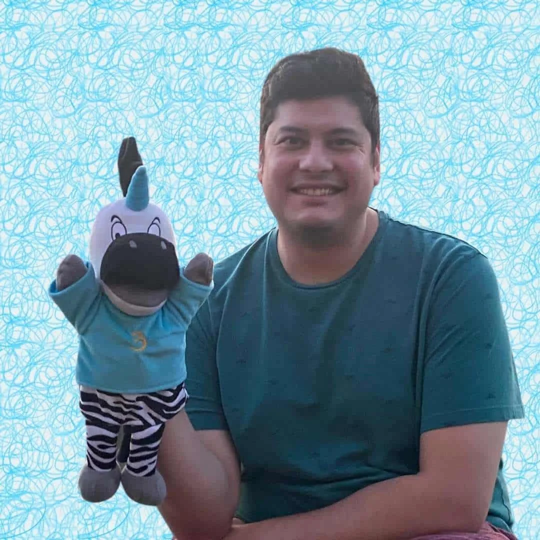 Matthew Vasquez holding Trezekke the Zebracorn puppet