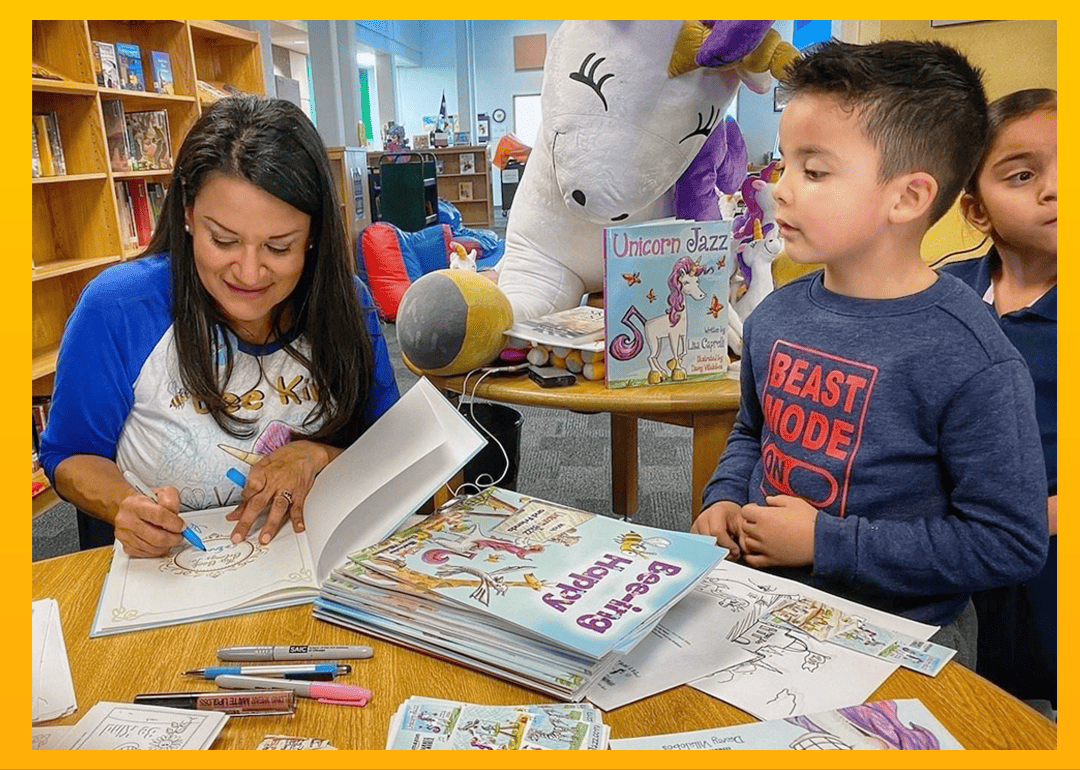 Lisa Caprelli signs a Unicorn Jazz book as children watch in a library.