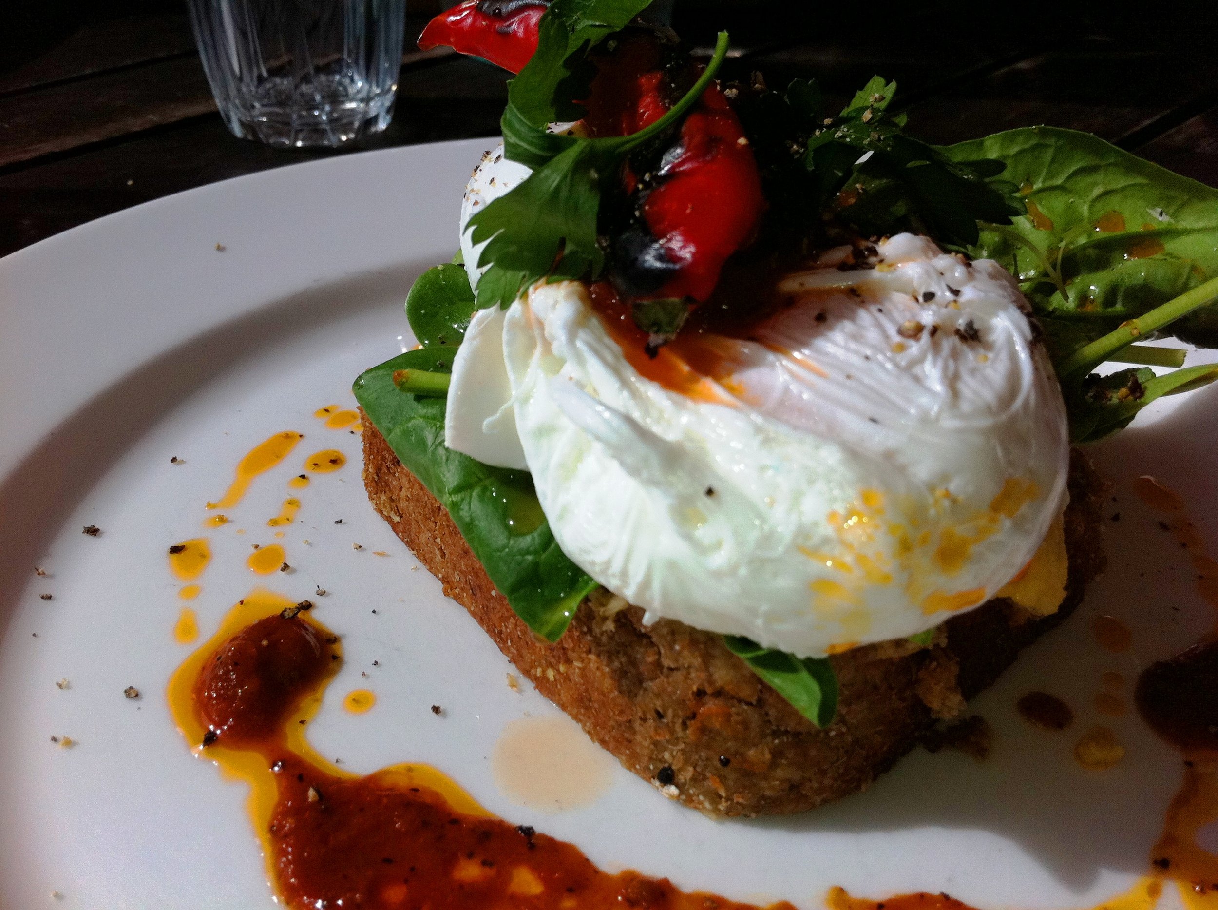 Raw Ezekiel Bread with Poached Eggs, Hummus, Spinach and Tomato Kusundi