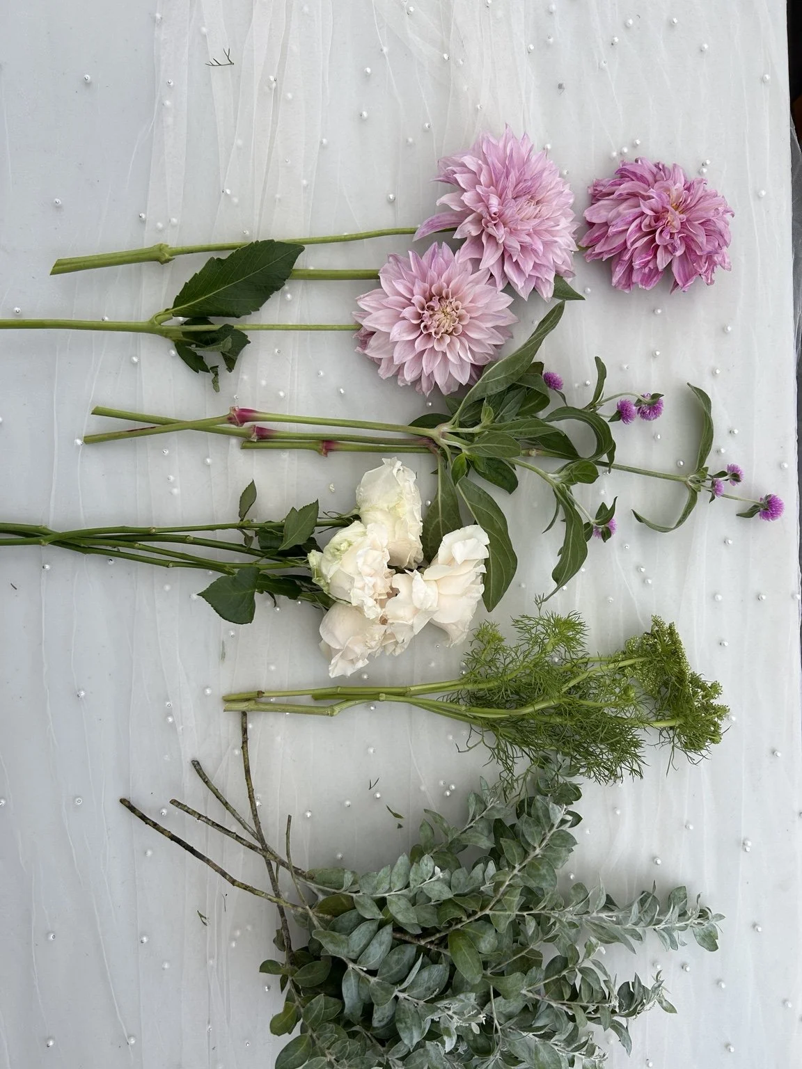 Dahlias, white blooms and greenery laid out for a workshop