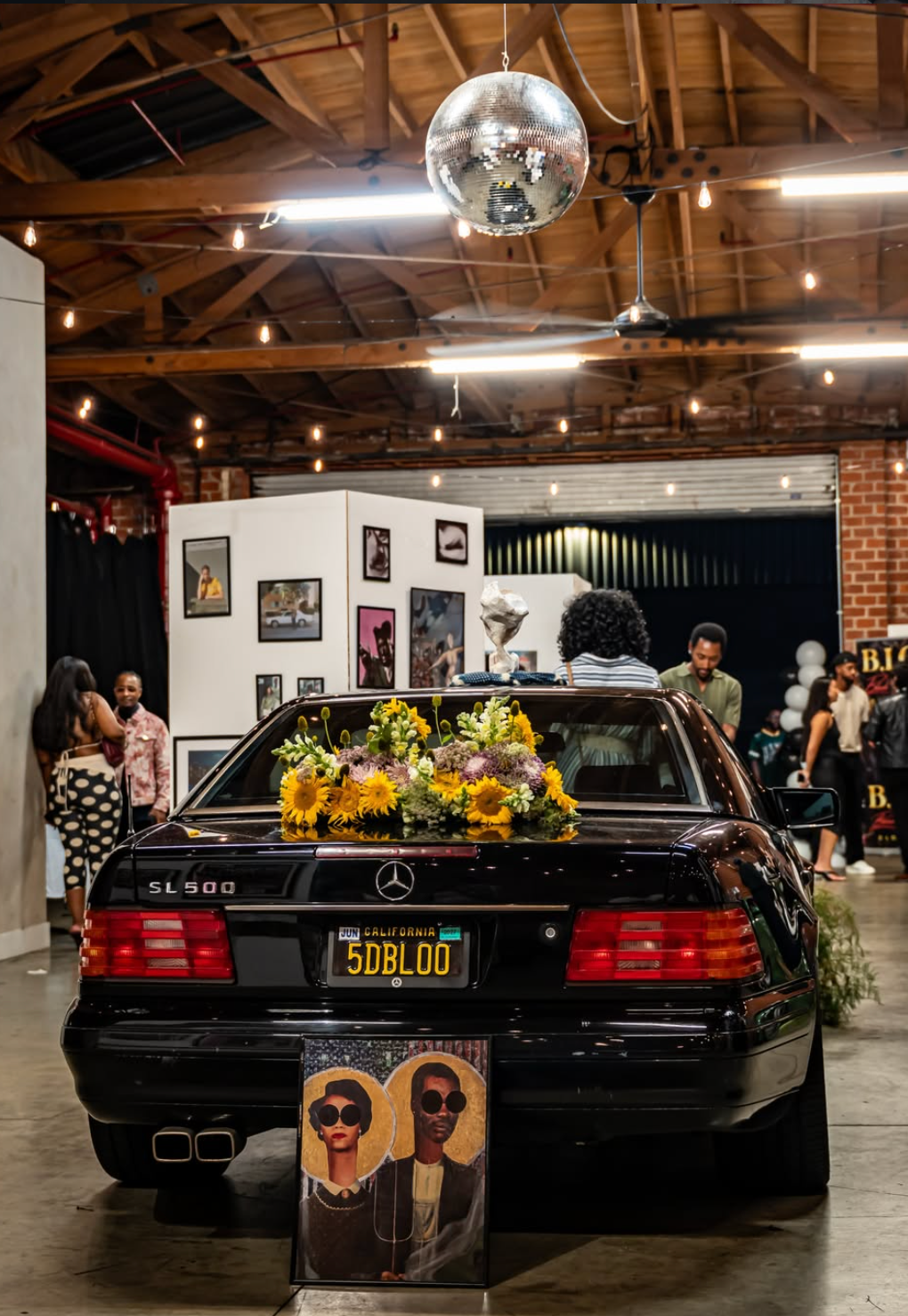 Black Mercedes with a sculptural floral installation at a car and art event