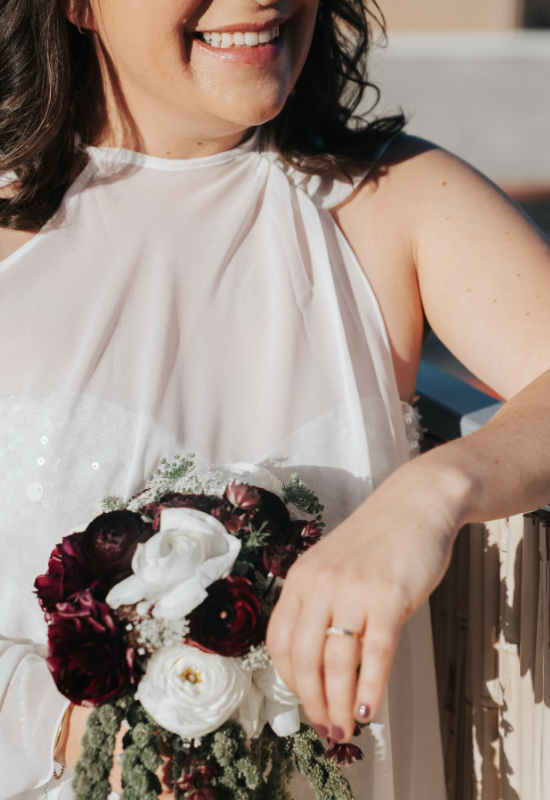 Guest holding a burgundy and white bouquet