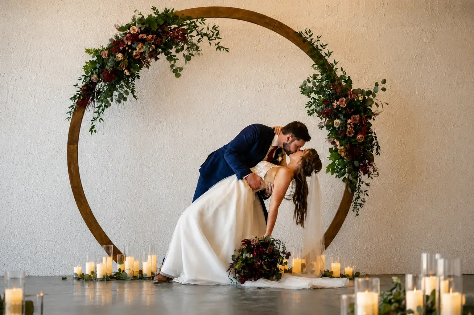 Newlywed couple beneath a floral wedding arch