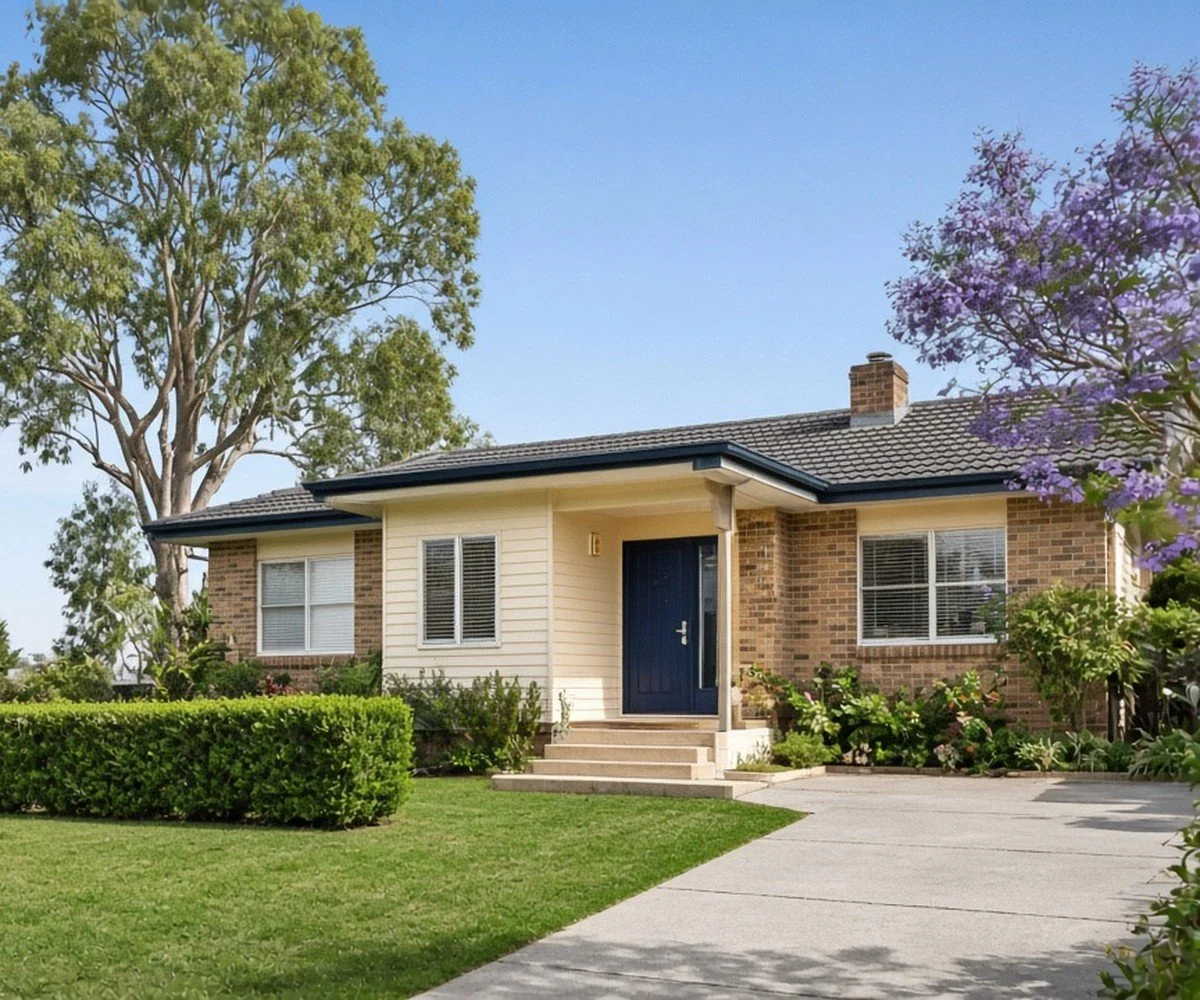 Well-kept rental home with a tidy lawn and hedges on a sunny day.