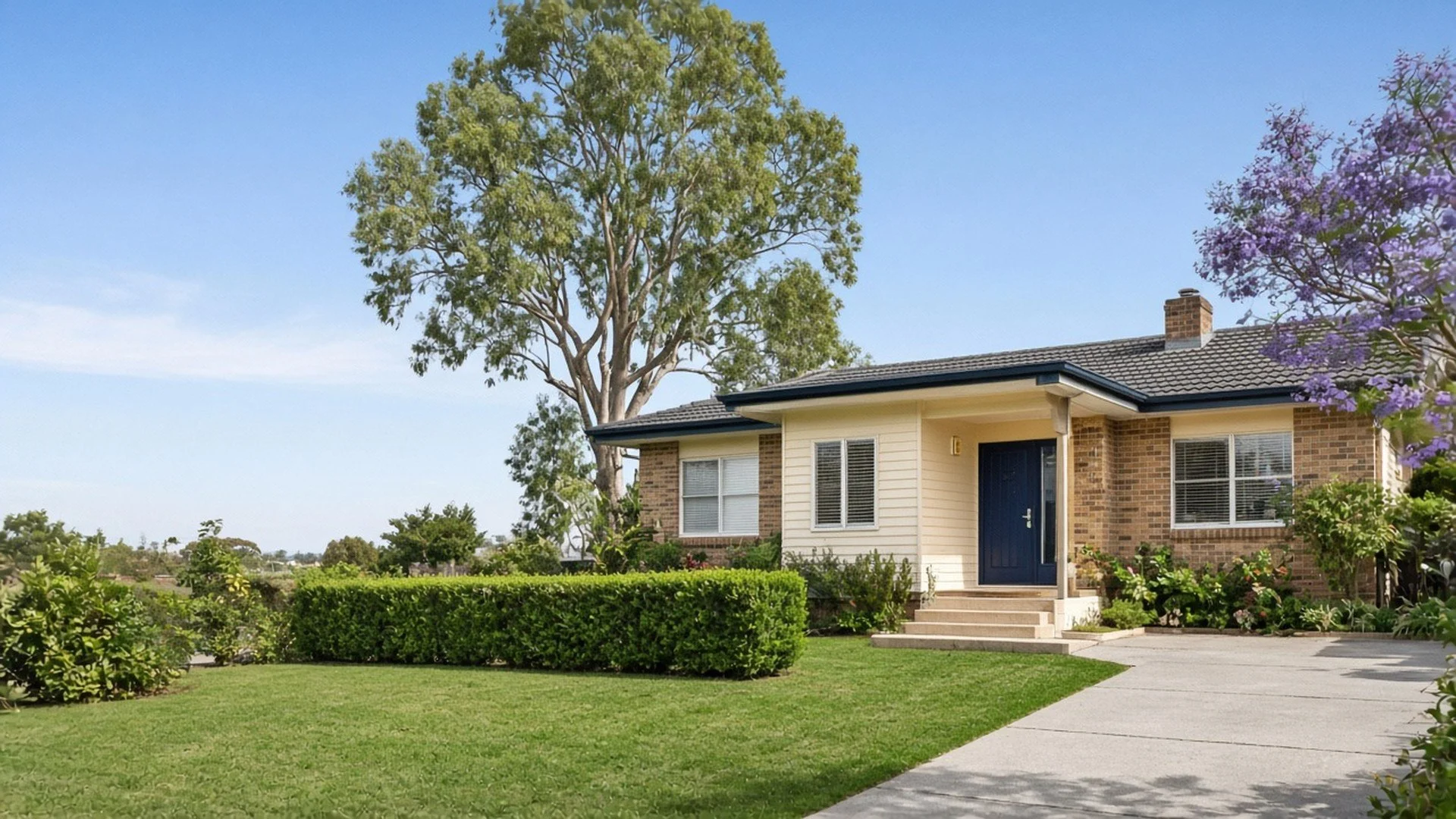Renovated brick and weatherboard family home with a navy front door and a leafy garden in a south-east Queensland suburb.
