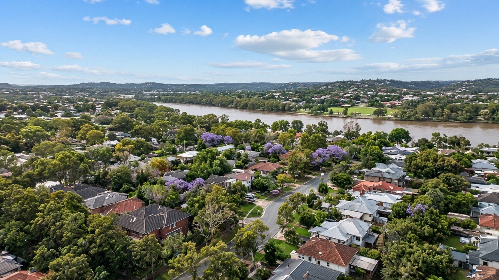 Aerial view of leafy Centenary suburbs beside the Brisbane River.