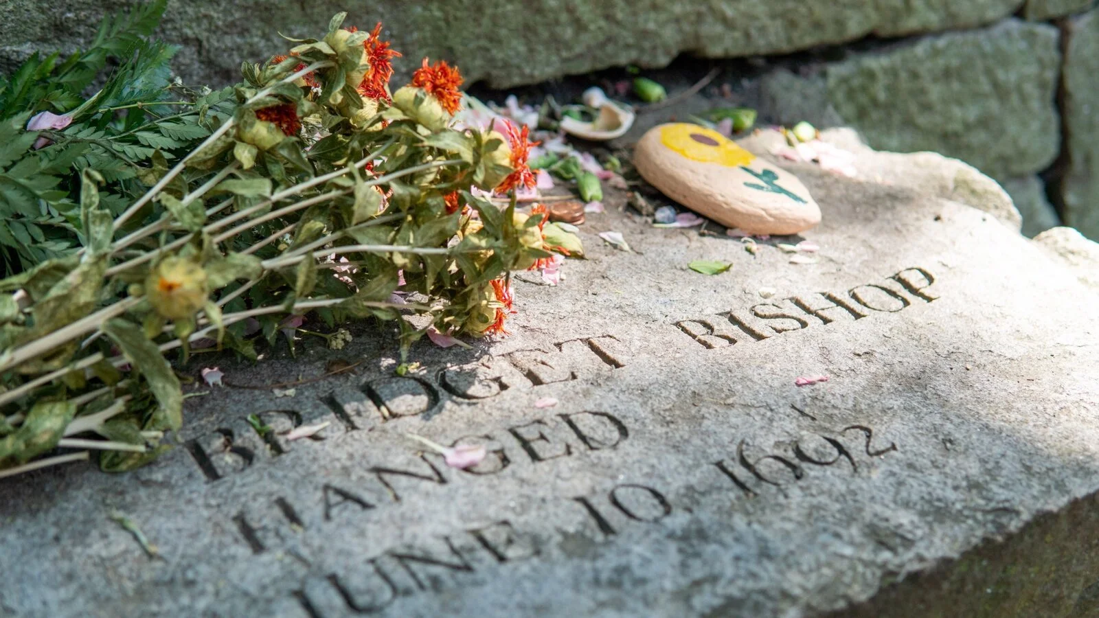 Bridget Bishop memorial bench with flowers