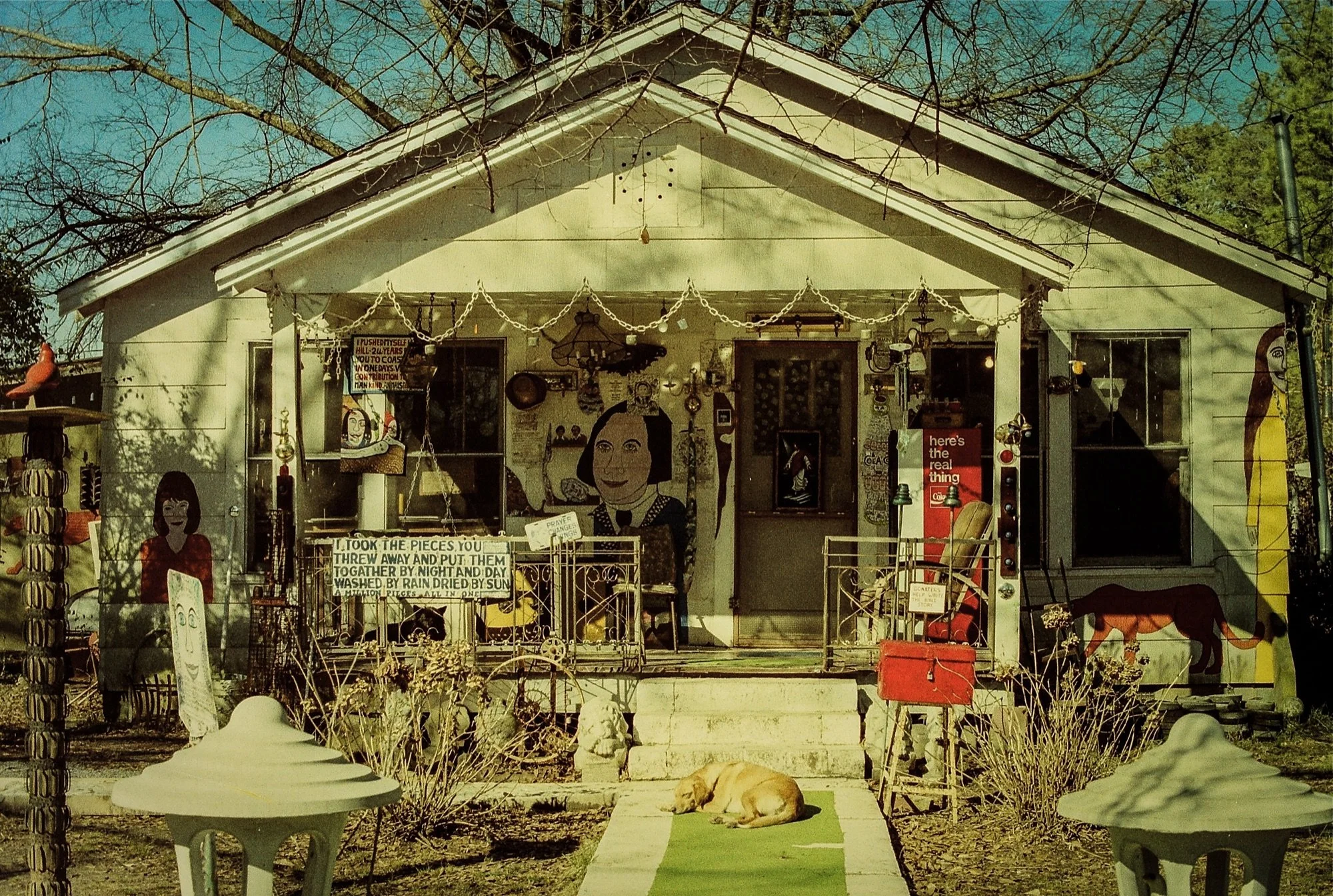 The exterior of Howard Finster’s house at Paradise Garden in the 1980s, covered with paintings, signs, found objects, and handmade structures