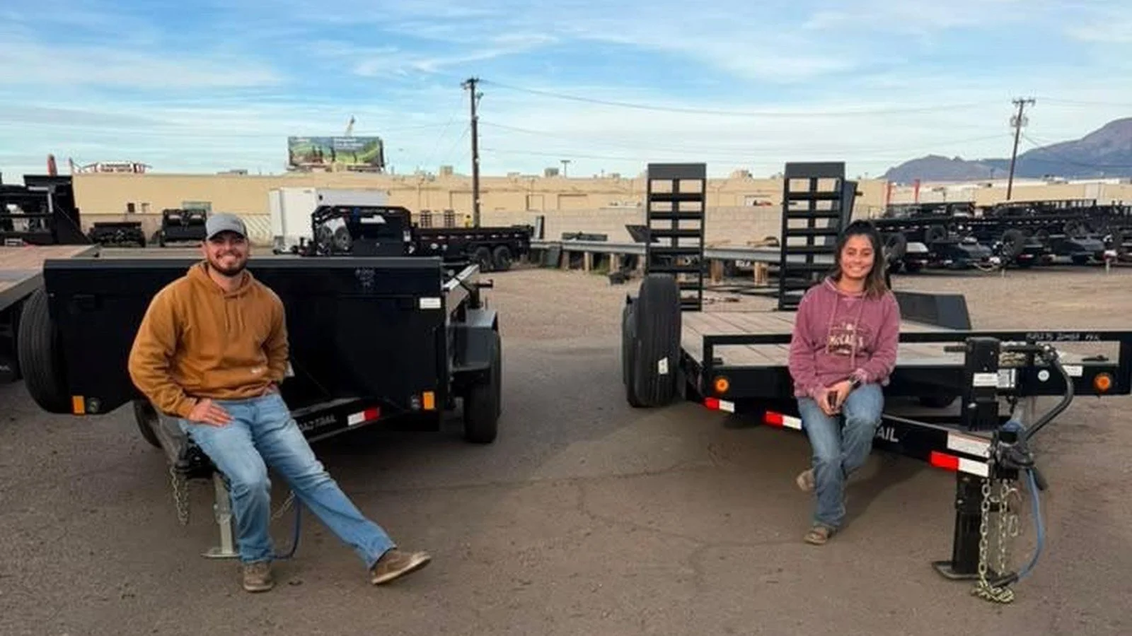 Owners Joseline and Mario seated on equipment trailers.