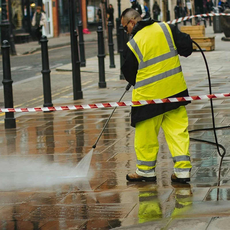 Professional pressure washing of a concrete sidewalk to remove dirt, stains and buildup