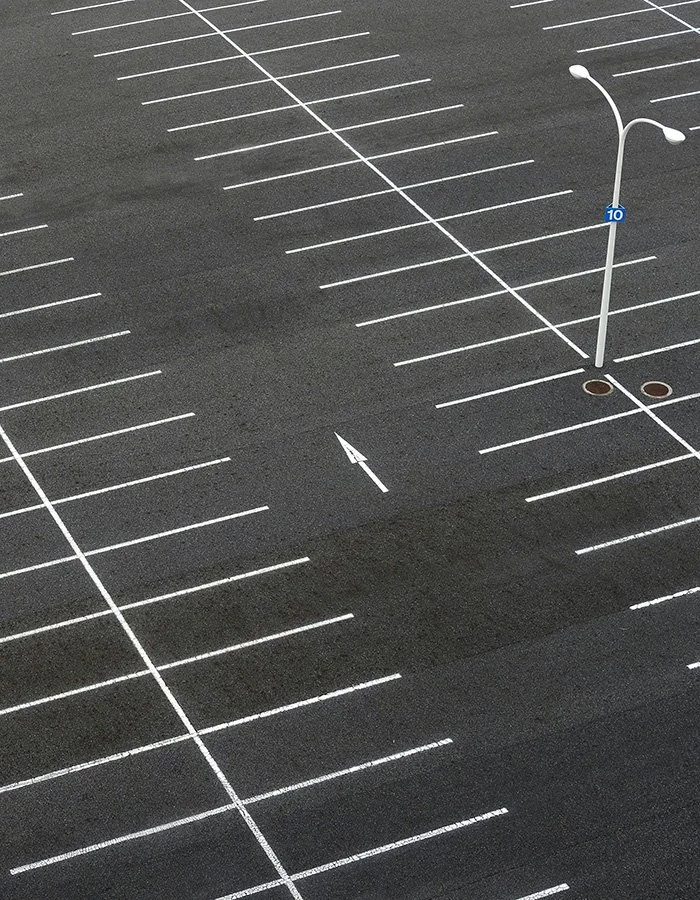 Freshly cleaned commercial parking lot with bright pavement markings after professional pressure washing