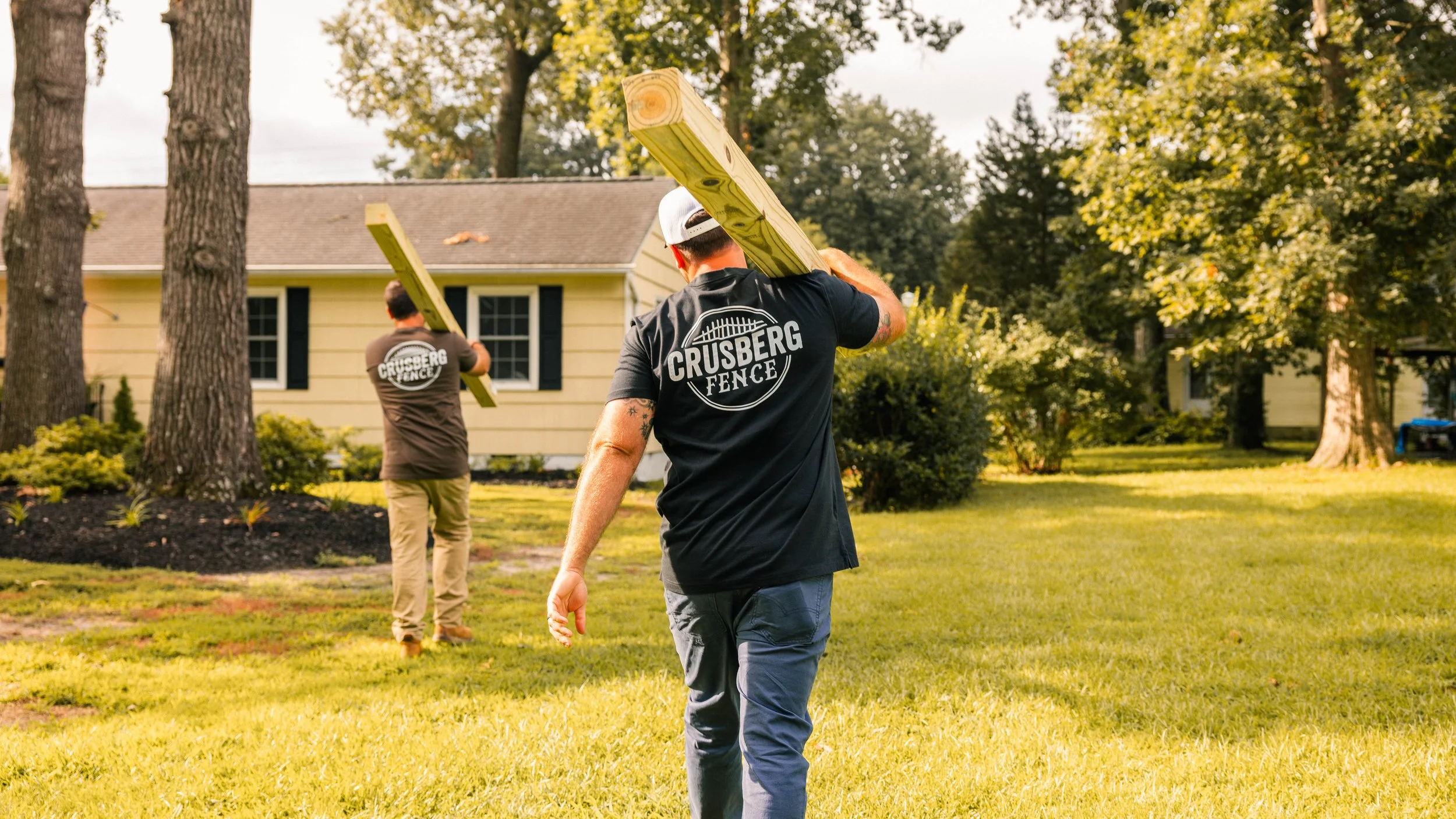 Crusberg Fence crew carrying boards on a Peninsula job