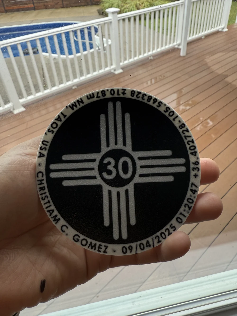 Posavasos personalizado en blanco y negro con el número 30, sostenido con una mano.