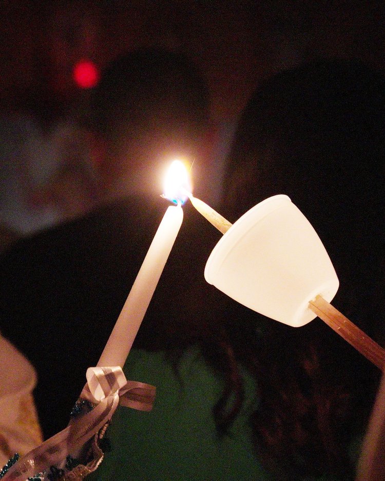One candle lighting another at the Paschal vigil