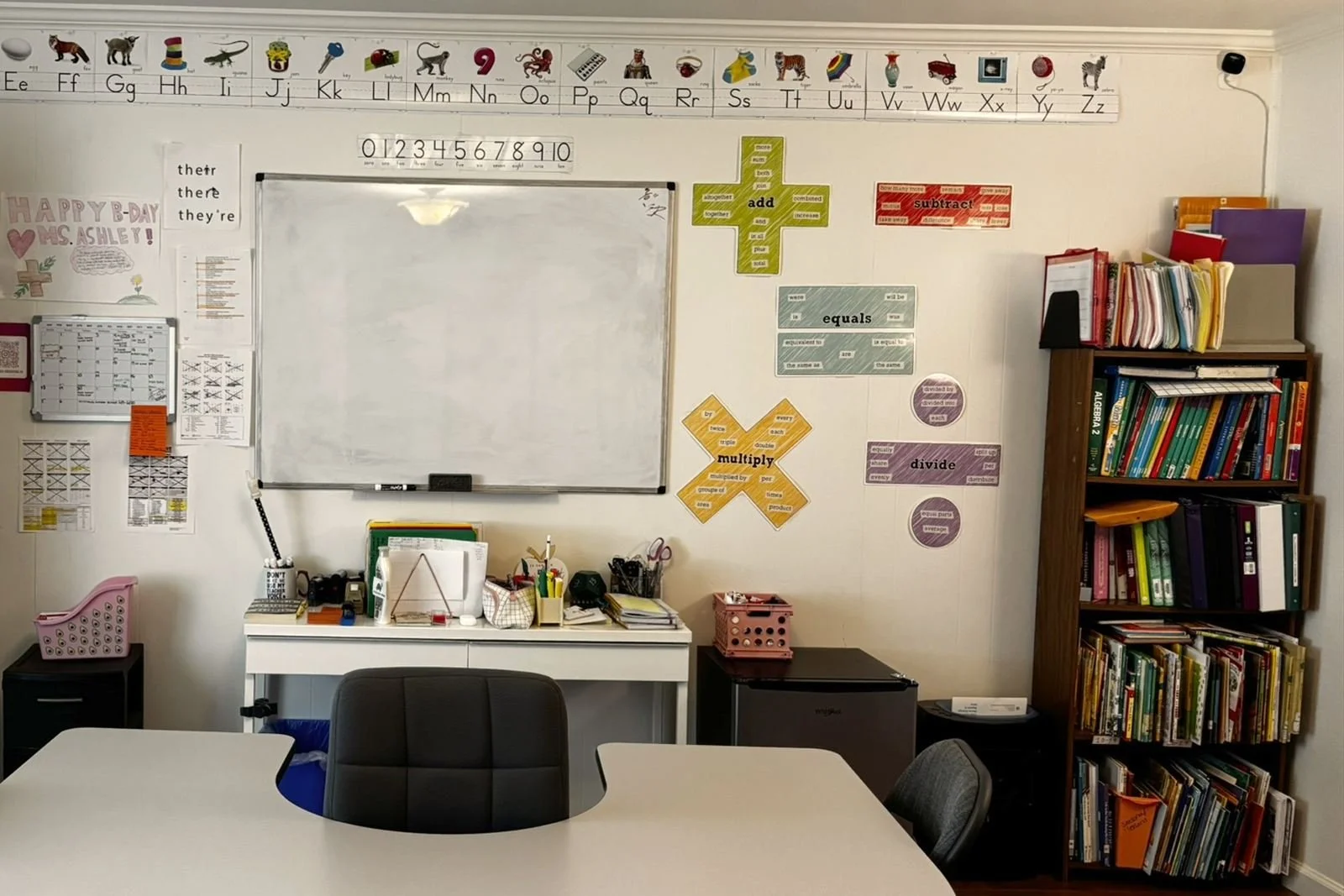 The tutoring classroom in Madera, with a work table, whiteboard, alphabet strip and reading shelves