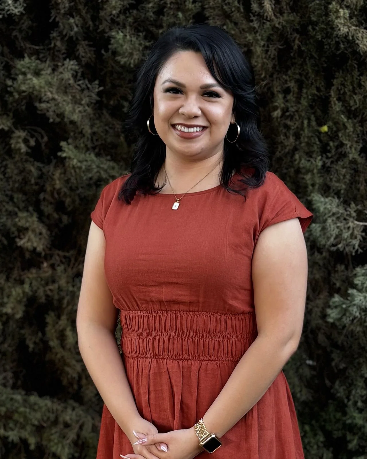 Ashley Guillen, standing outdoors in front of a hedge