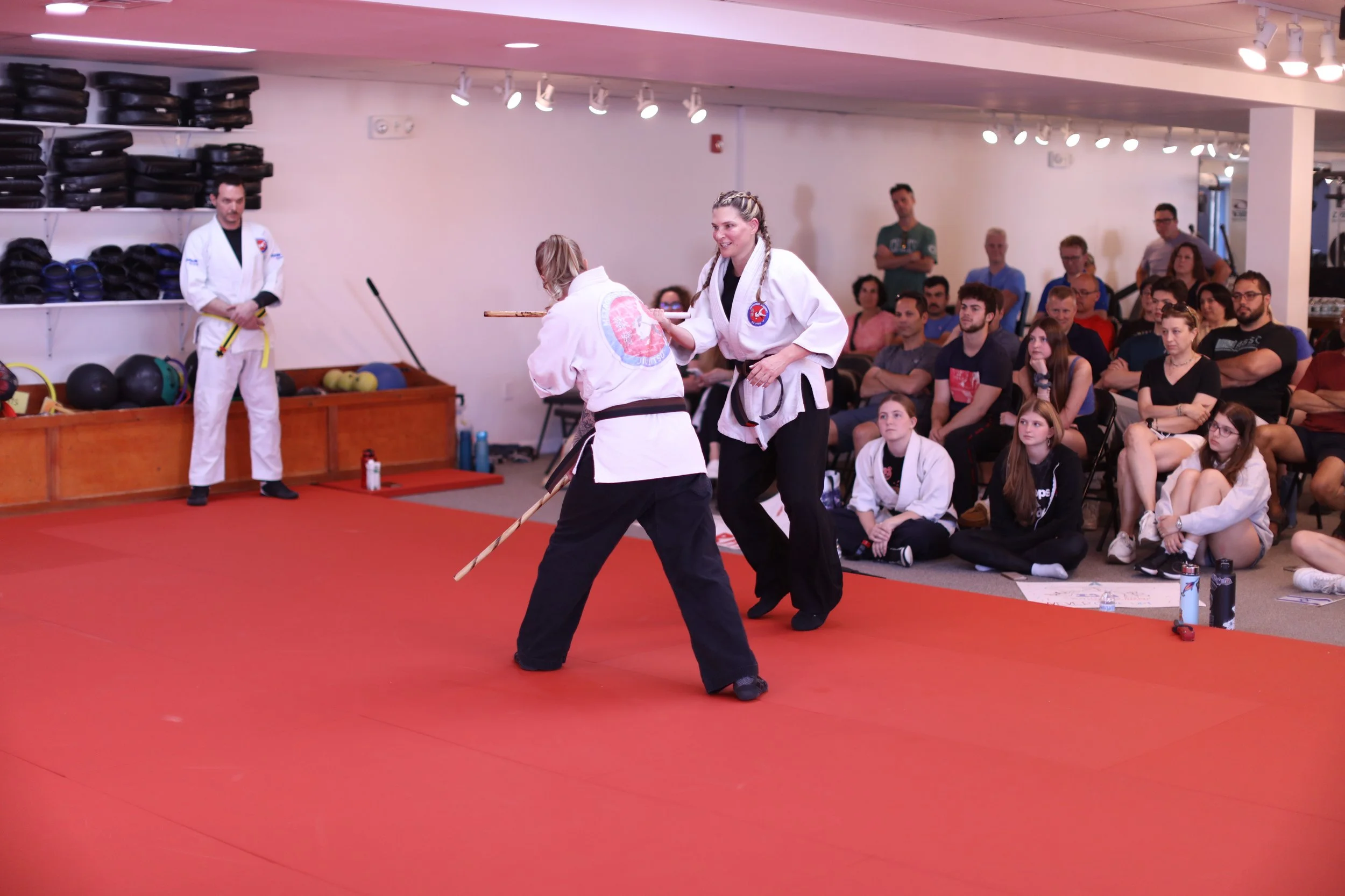 Training partners practicing with sticks at the Academy
