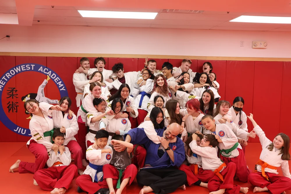 Academy students enjoying a playful group moment on the mat