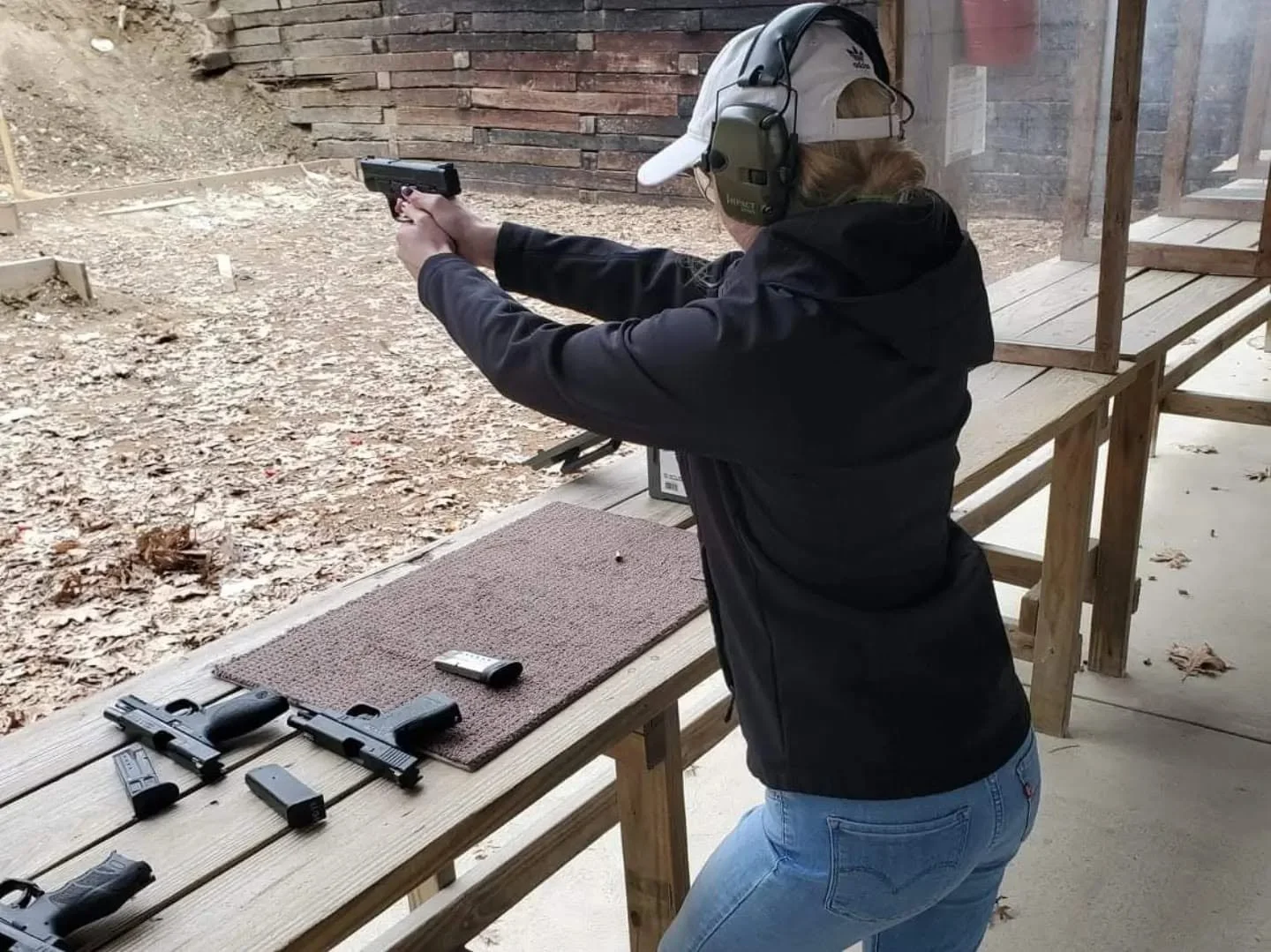A participant wearing hearing protection during practice at an outdoor range