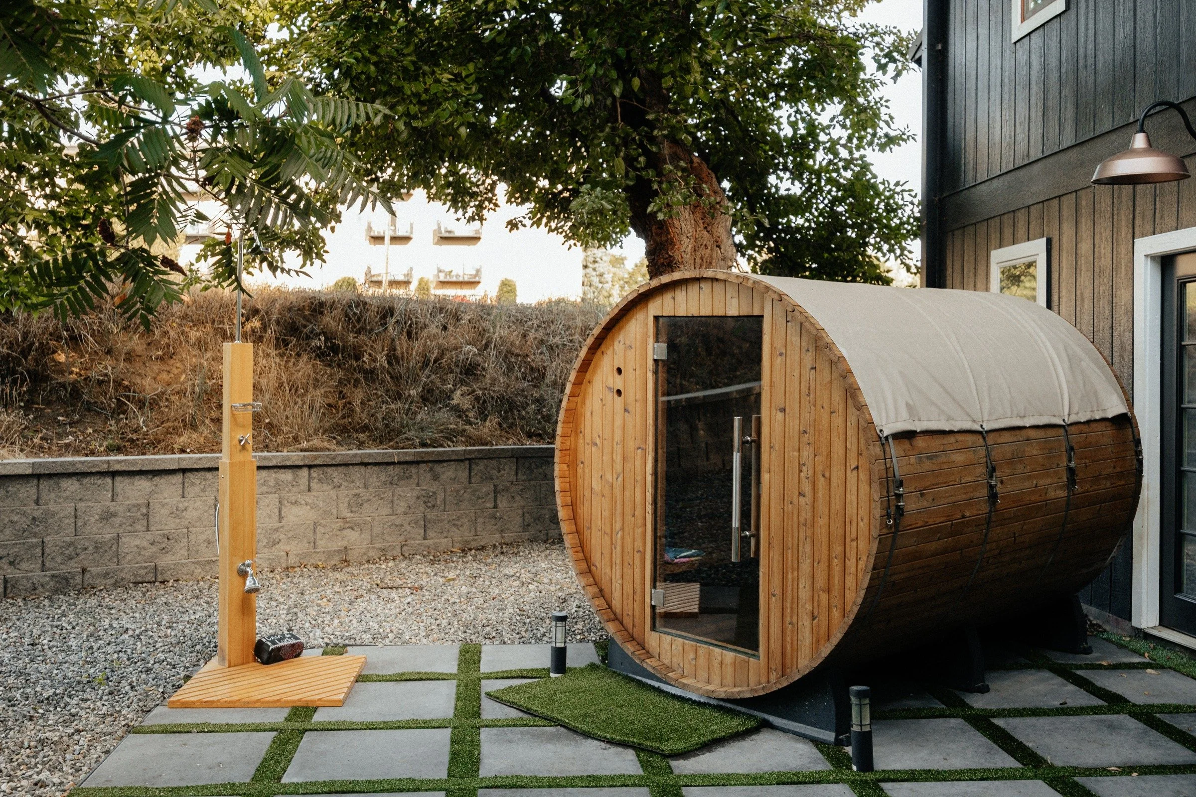 Wooden barrel sauna beside the farm building
