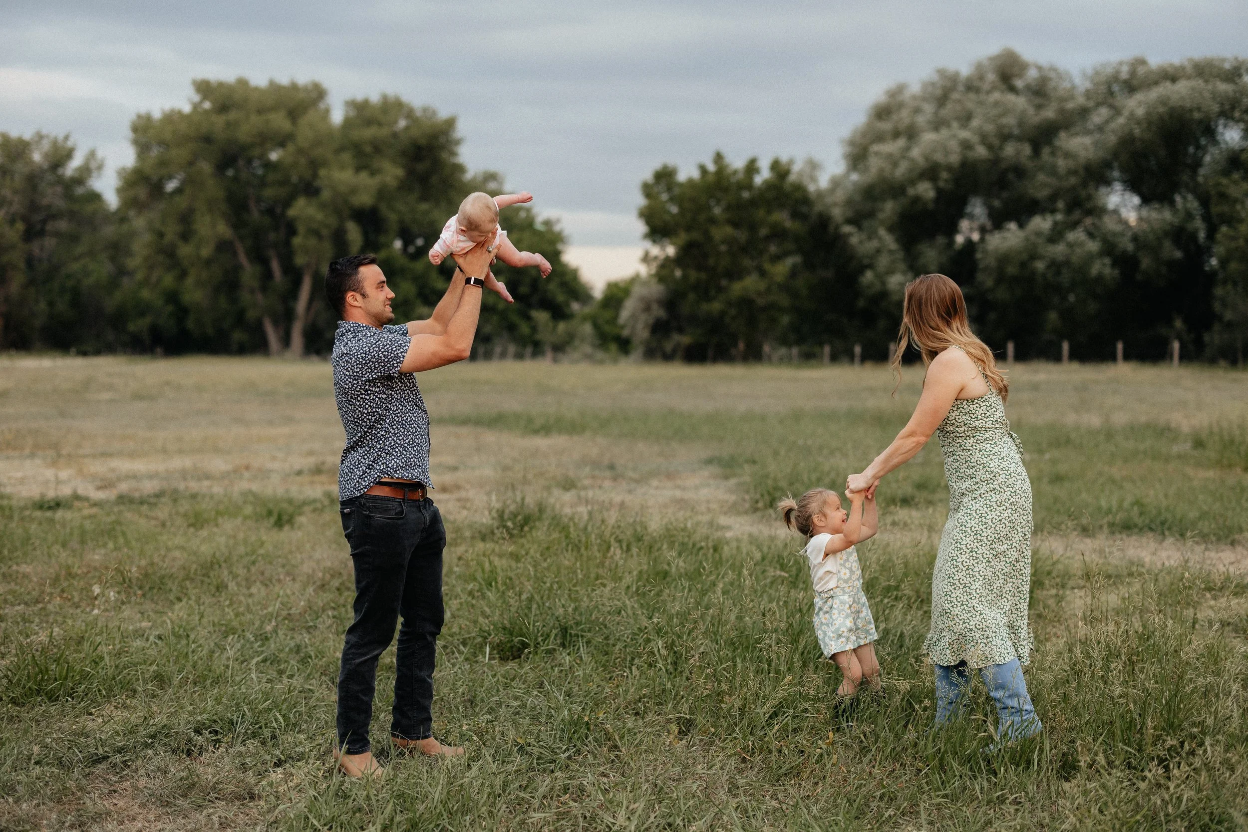 Parents playing with their children in the pasture