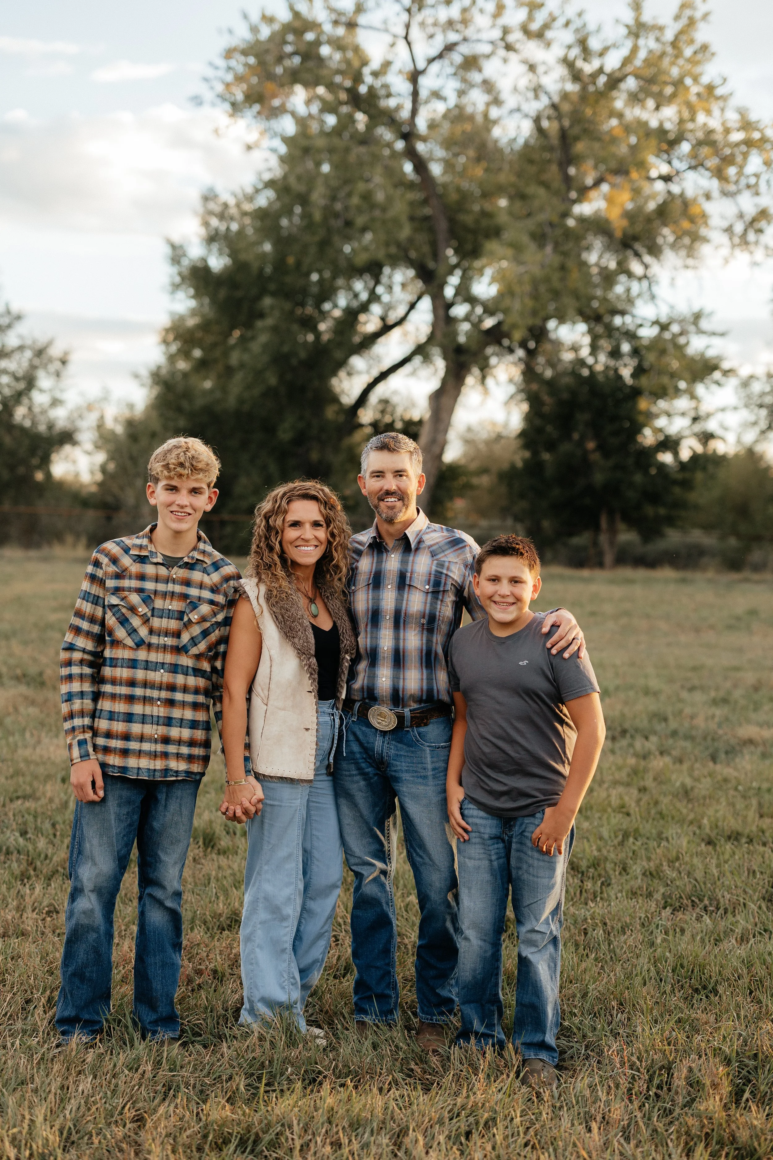 Family portrait beneath a tree in the farm pasture