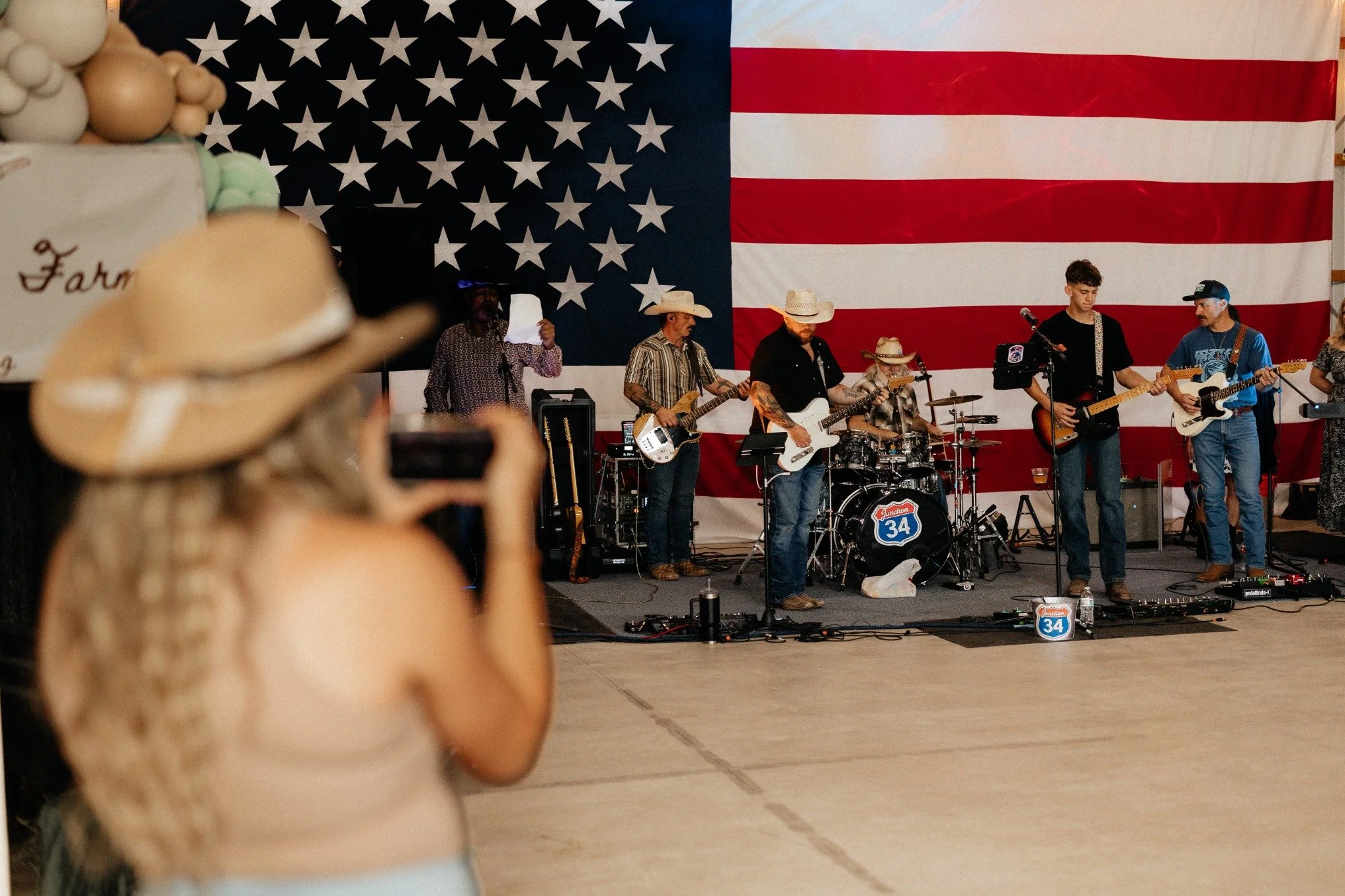 Live band playing in the gathering barn in front of an American flag