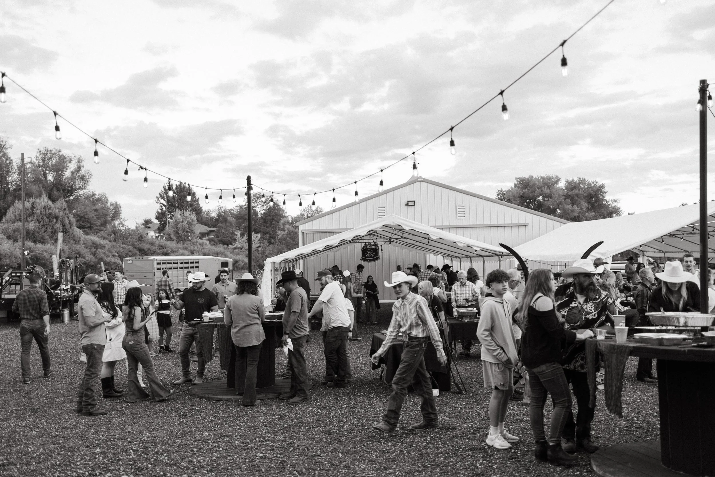 Guests celebrating outside the barn under string lights