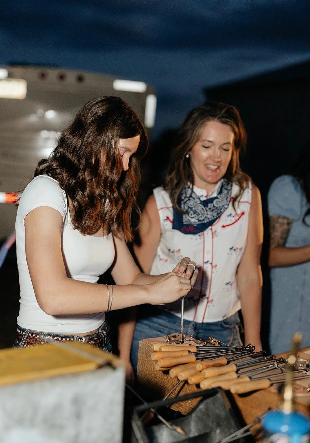 Guests personalizing leather keychains at a farm gathering