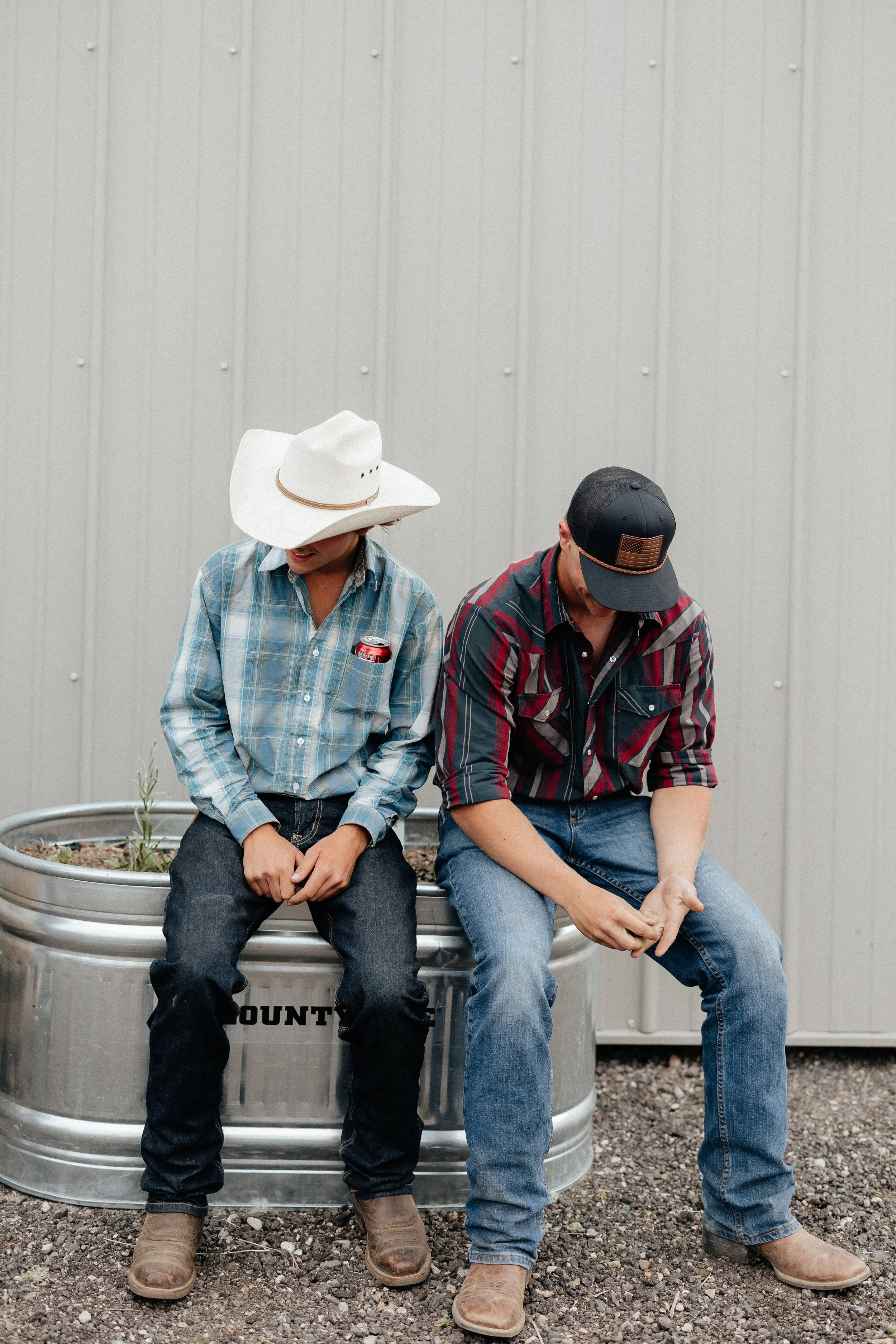 Two guests sitting together beside the barn at a farm celebration