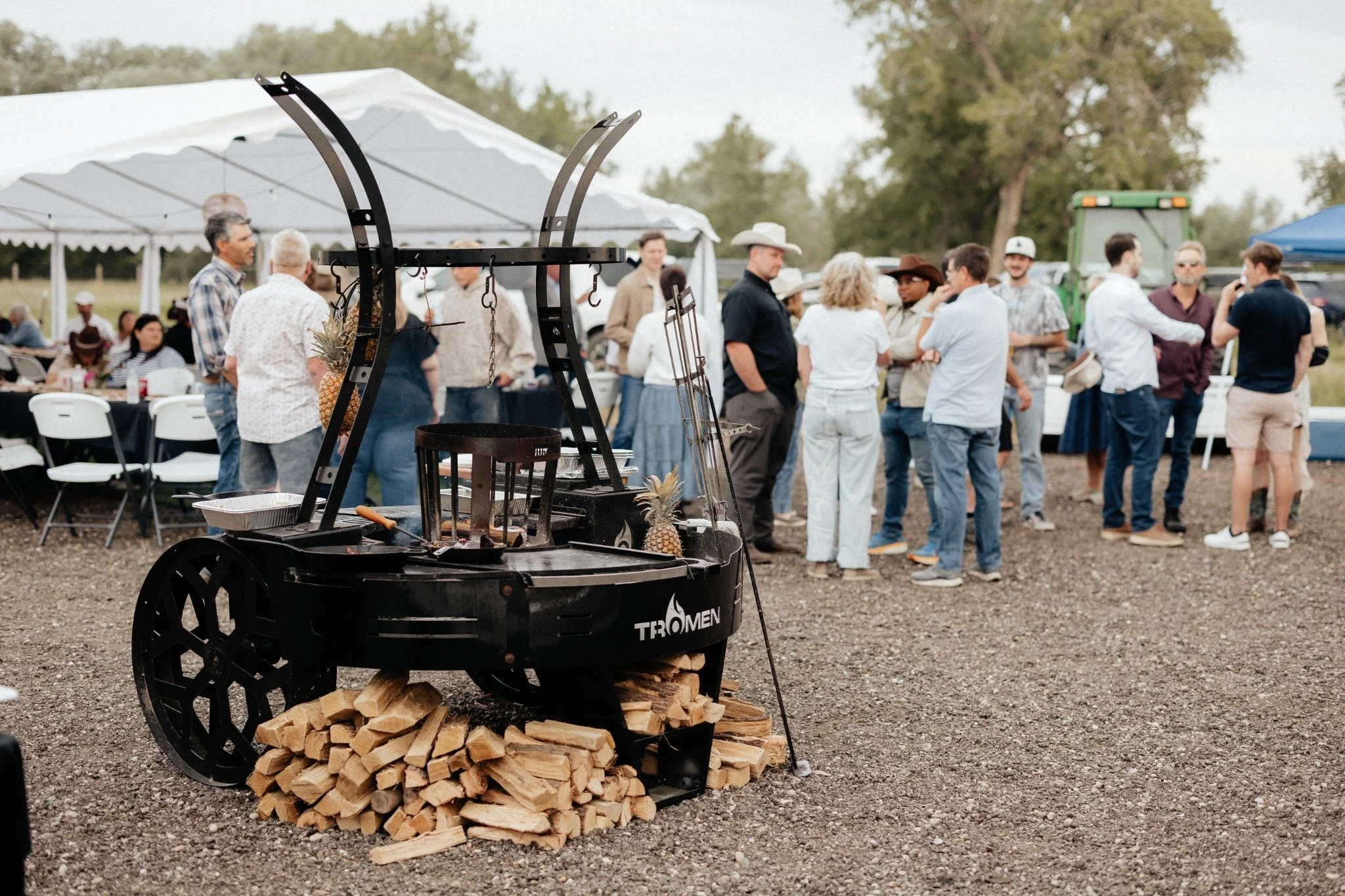 Food cooking over a wood-fired grill at a farm gathering