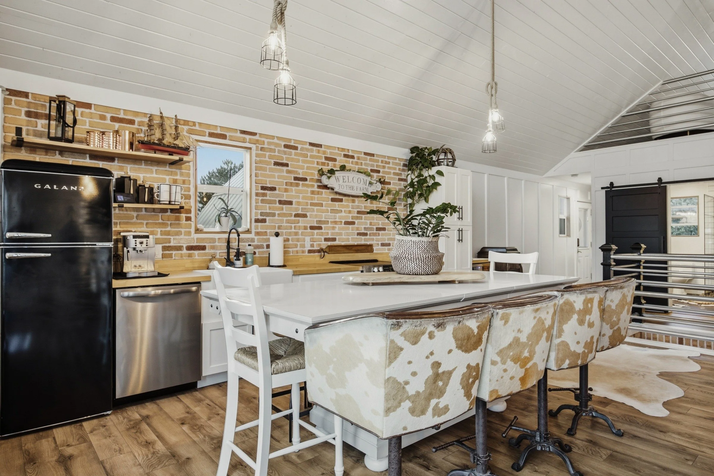 Full kitchen with farmhouse sink, stove, refrigerator and island seating