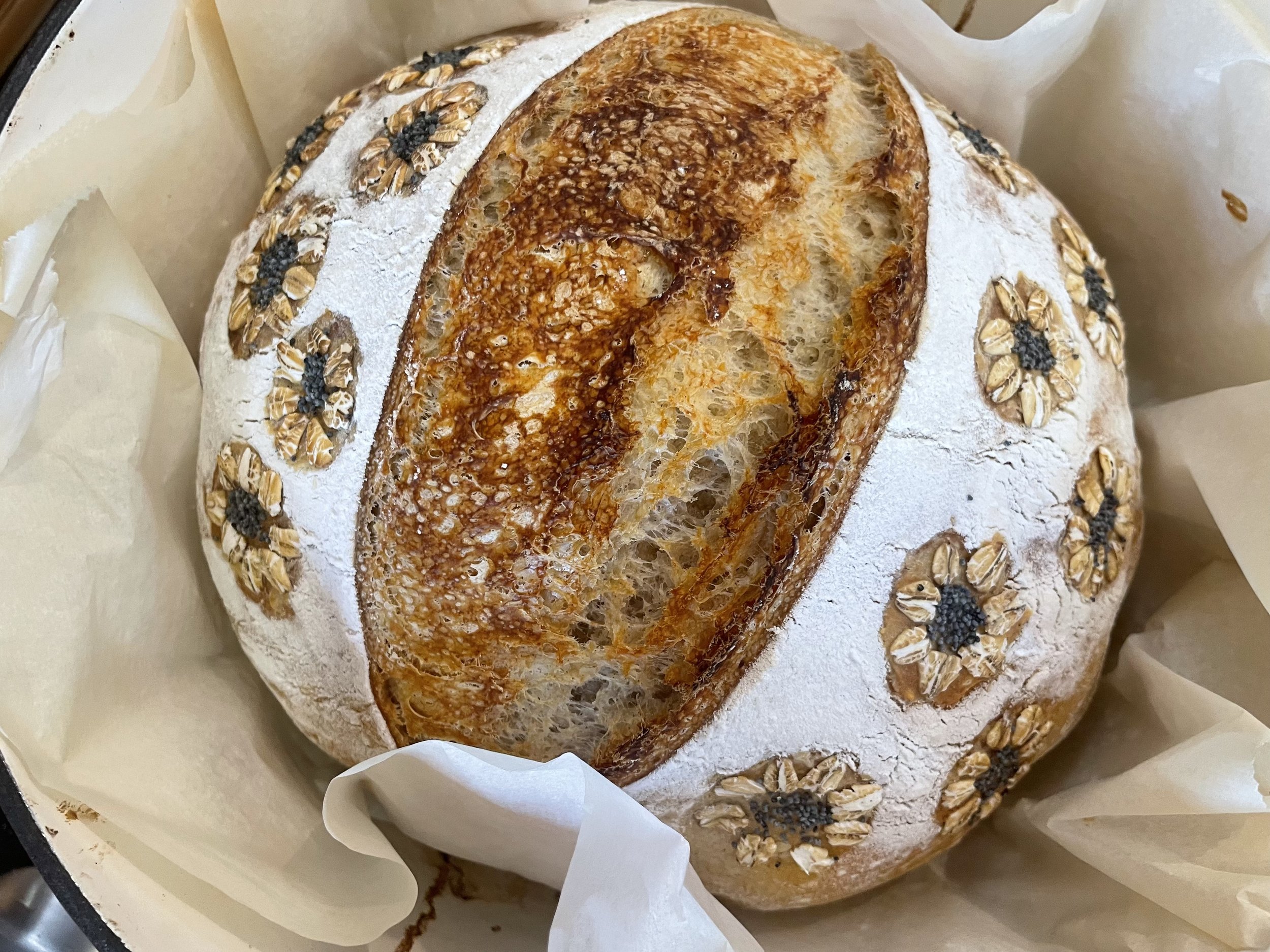 Golden sourdough loaf with decorative scoring in a Dutch oven