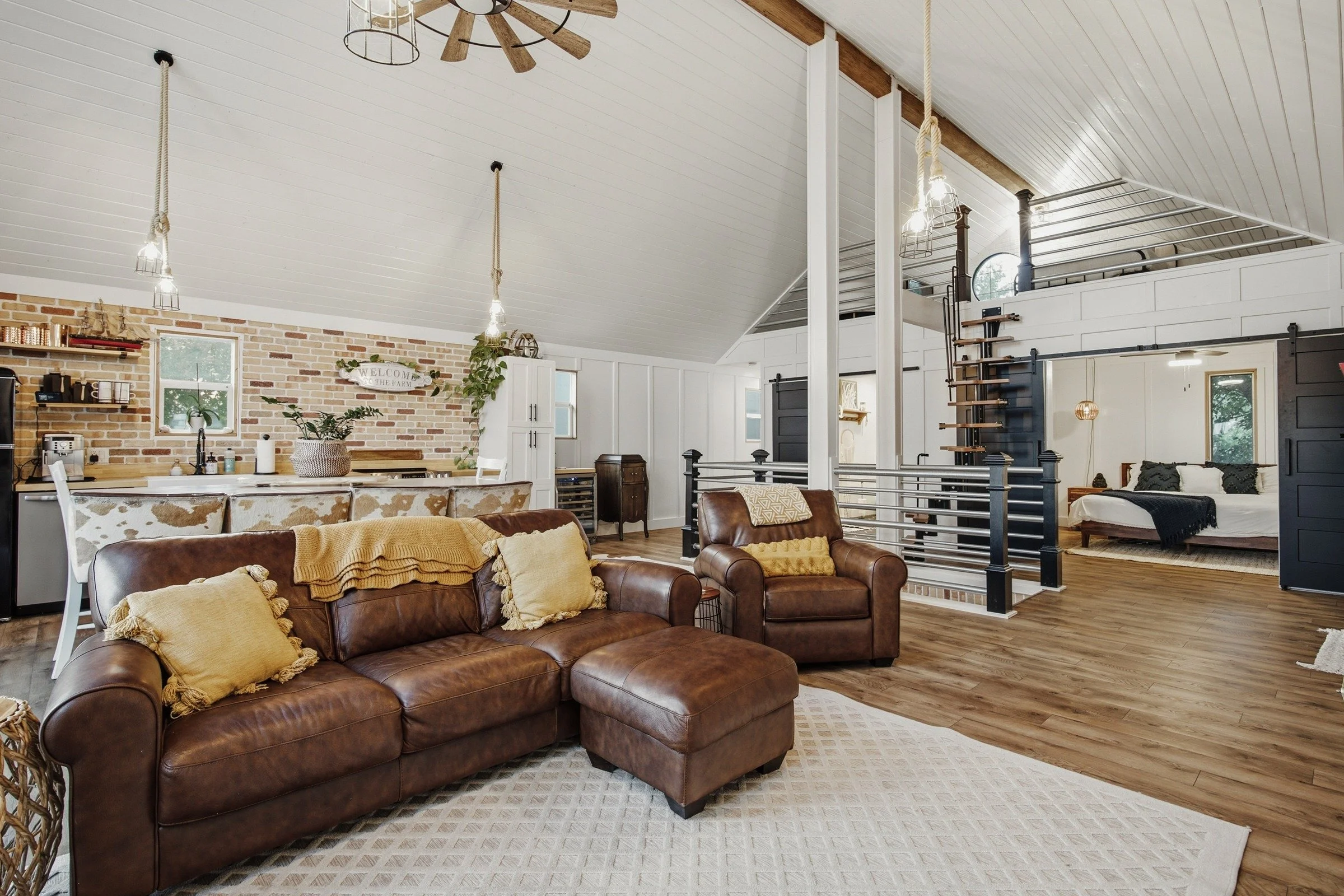 Open loft living room with leather seating, full kitchen and sleeping areas
