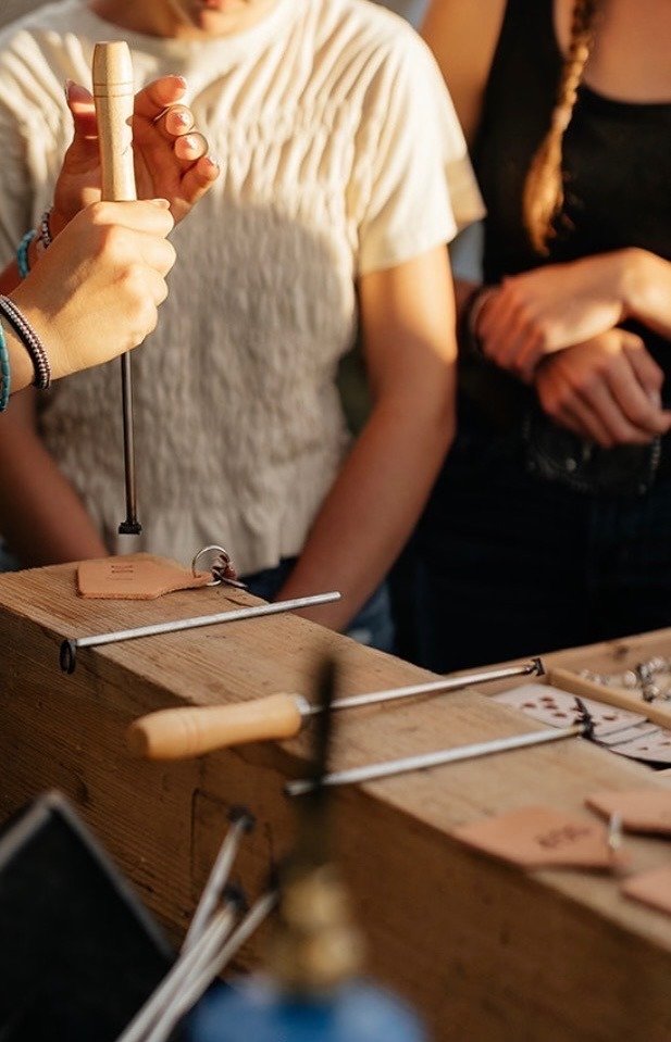 A guest stamping a leather keychain