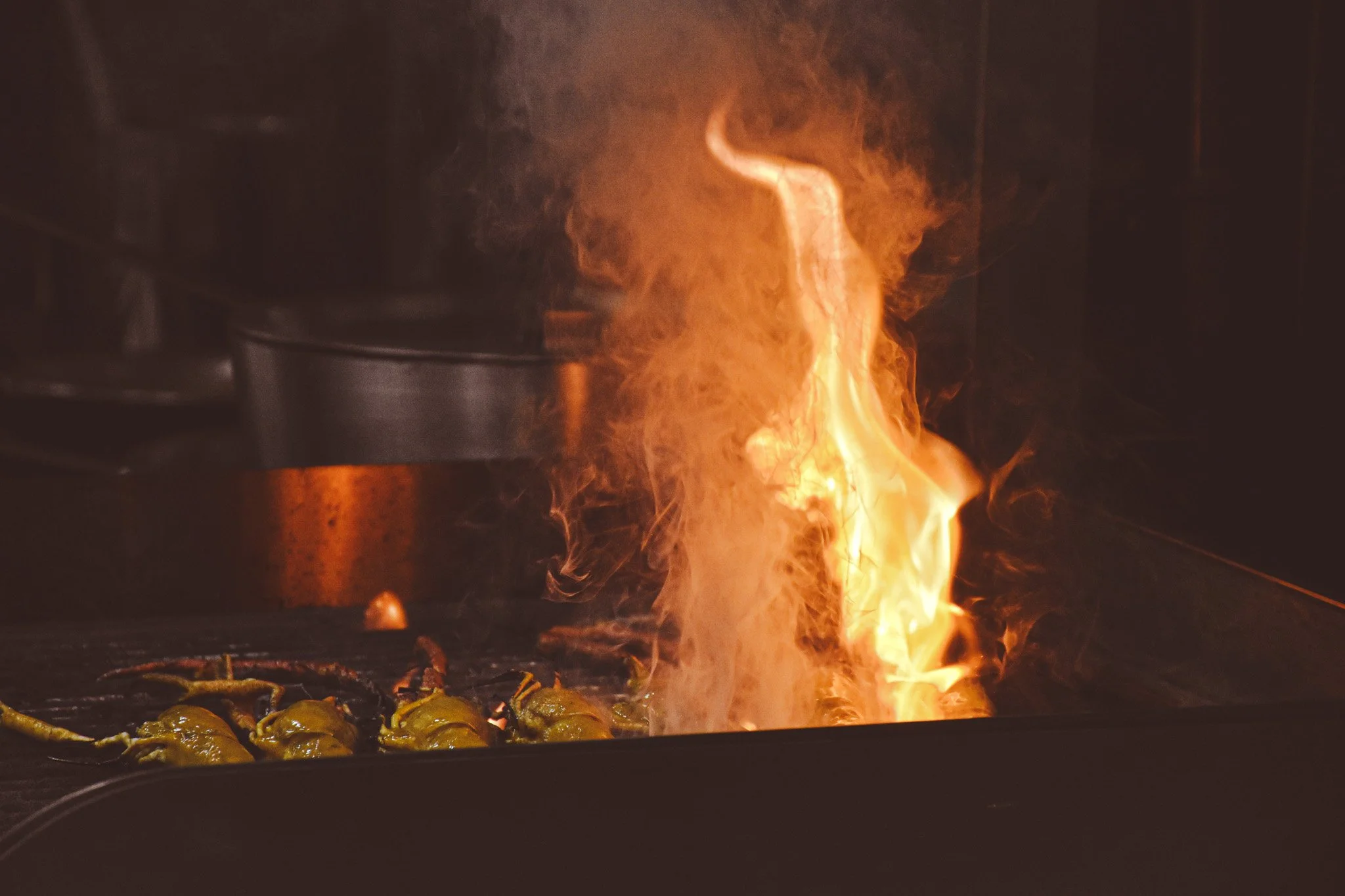 Peppers on the grill under a tall flame.