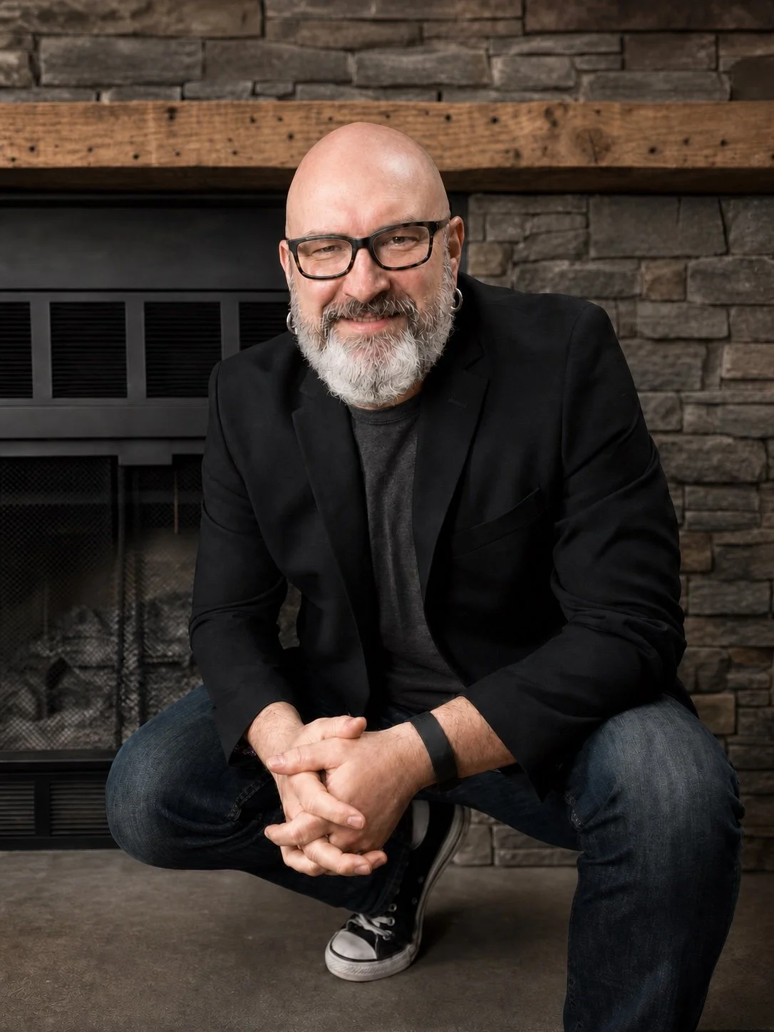 Bradley Grinnen seated in front of a stone fireplace