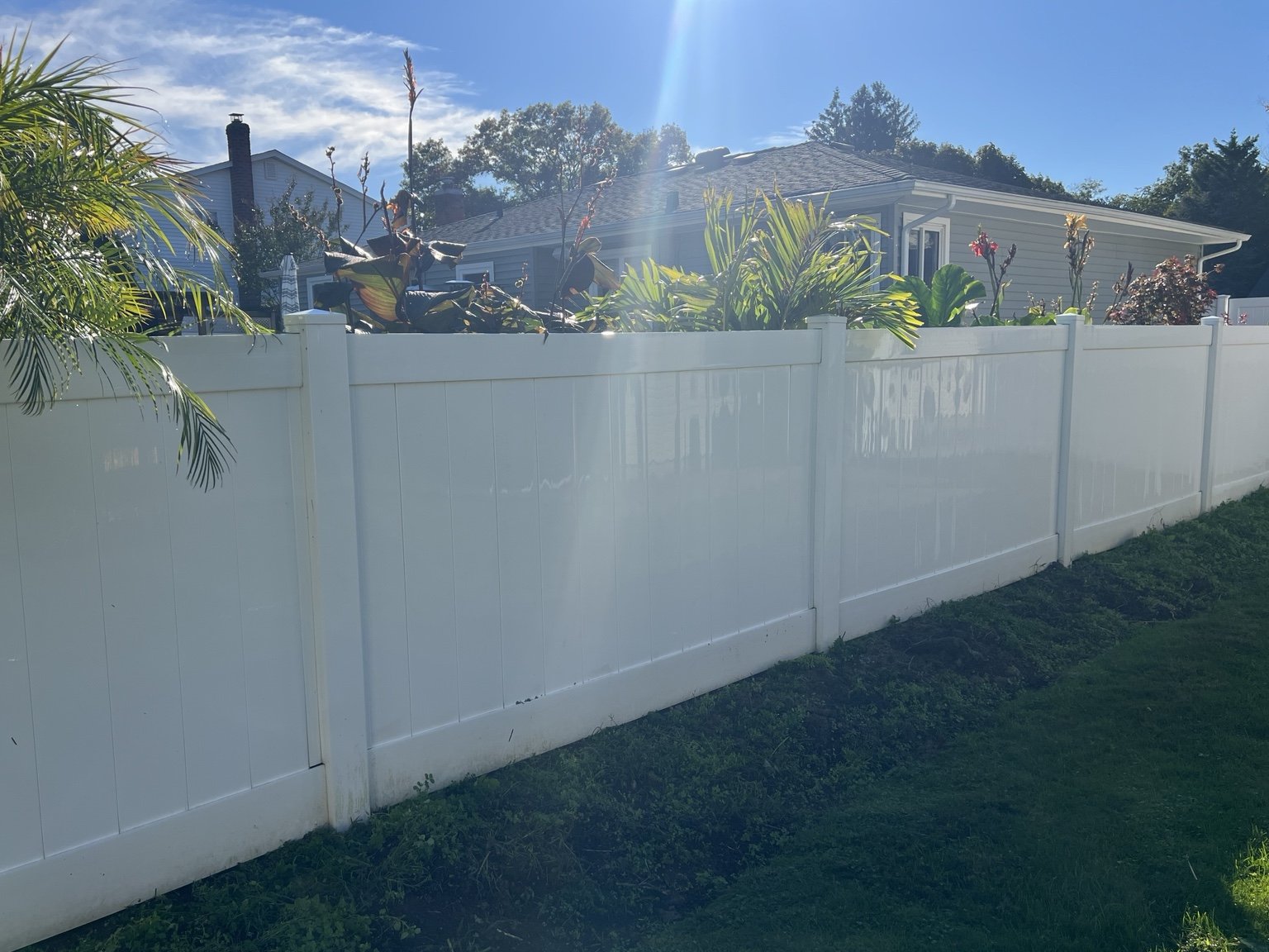 The same white PVC fence after cleaning, with visibly cleaner panels and rails