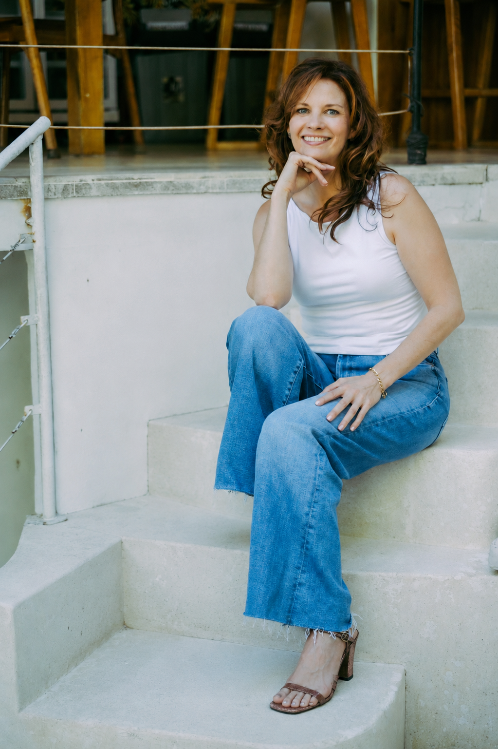Anna Curran, comedy screenwriter and artist, seated on pale stone steps