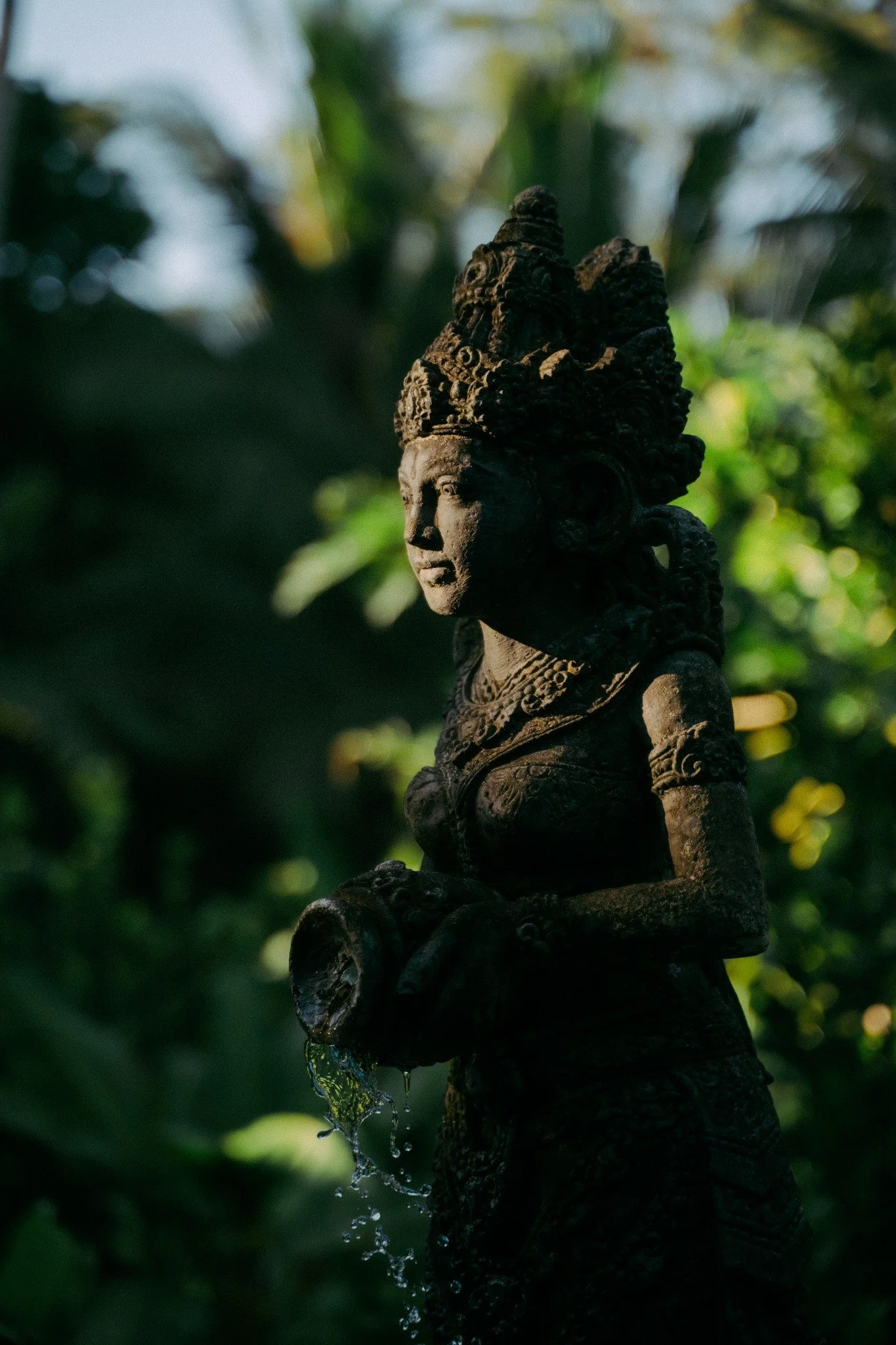 Balinese stone water statue in a garden in Ubud