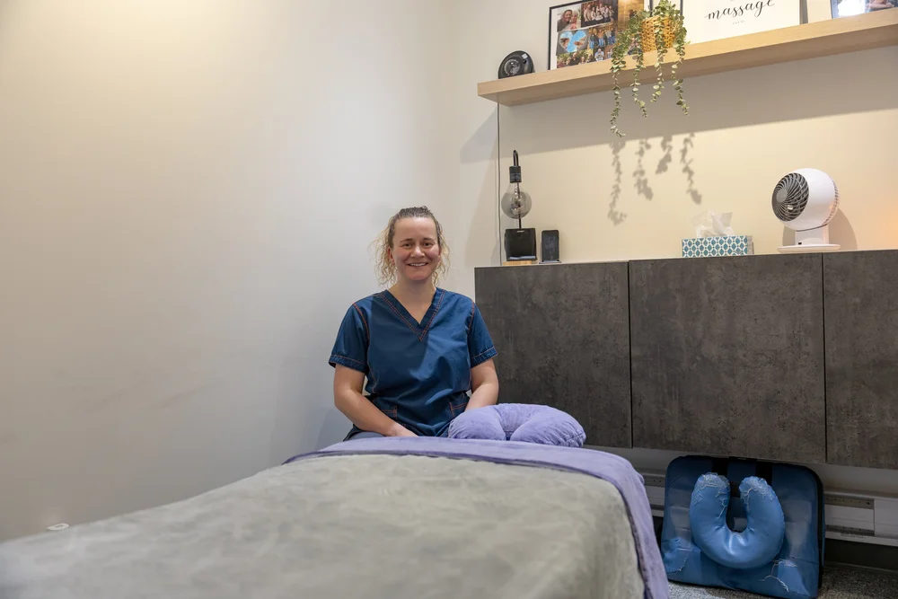 Massage therapist seated in a Back On Track treatment room