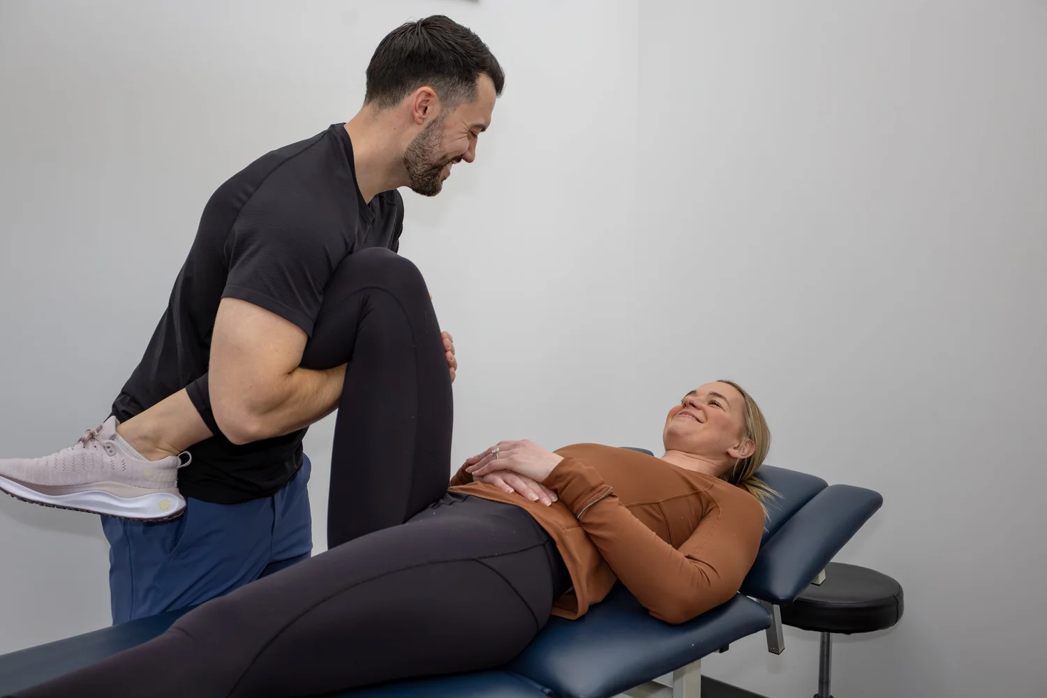Physiotherapist working with a patient during a hands-on leg assessment